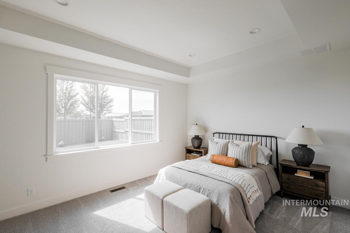 Bedroom featuring carpet flooring, a tray ceiling, and recessed lighting