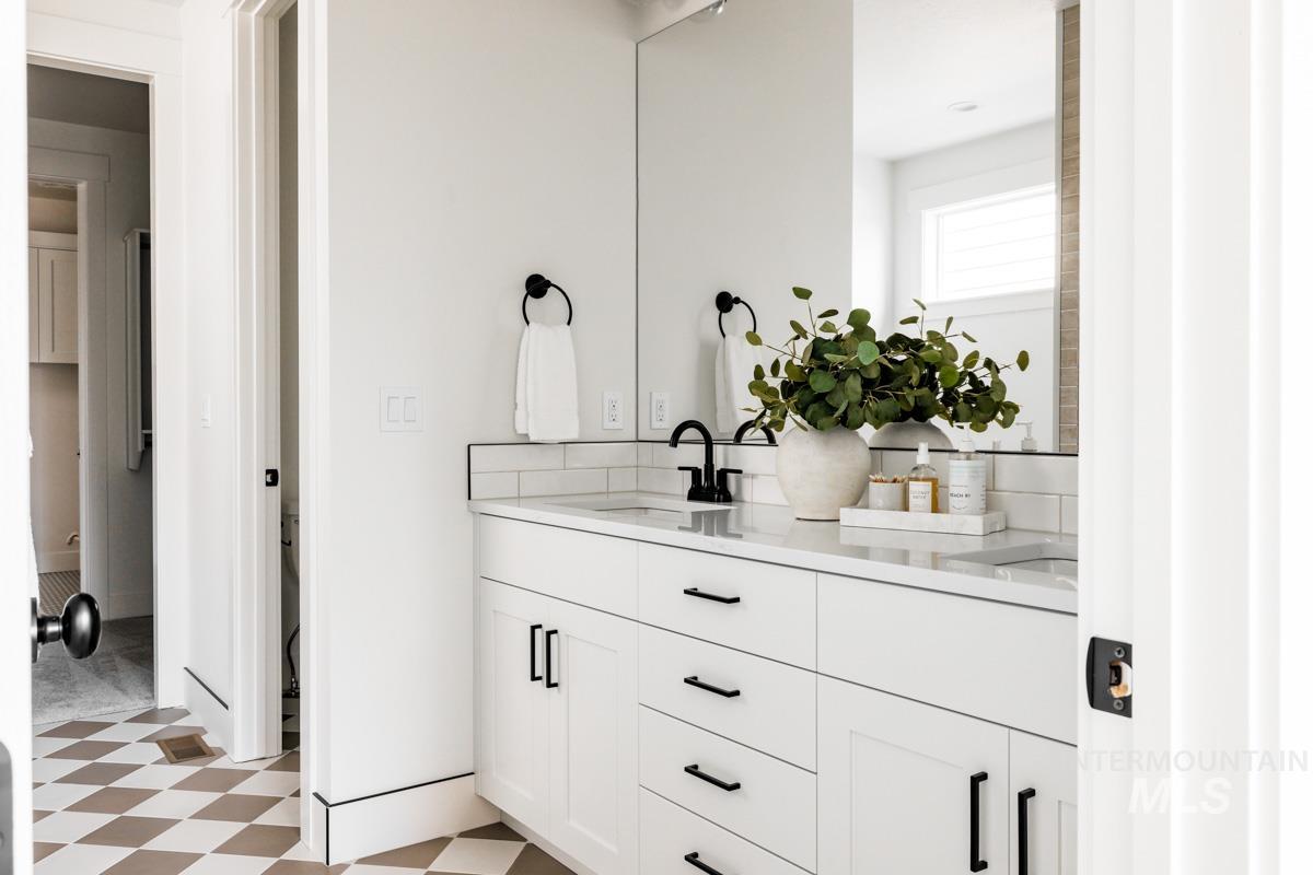 Bathroom featuring light floors and double vanity