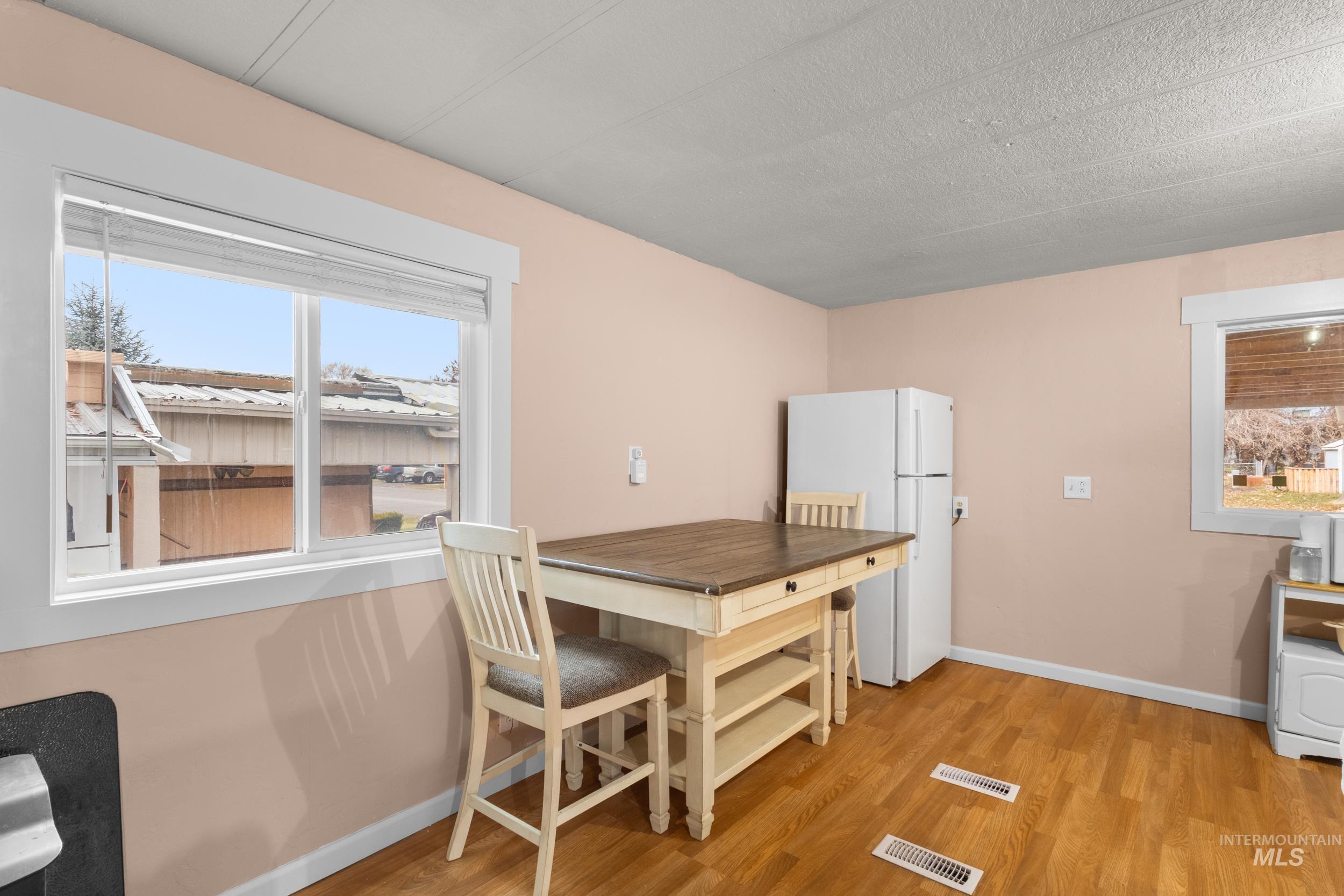 Kitchen with freestanding refrigerator and light wood-style floors