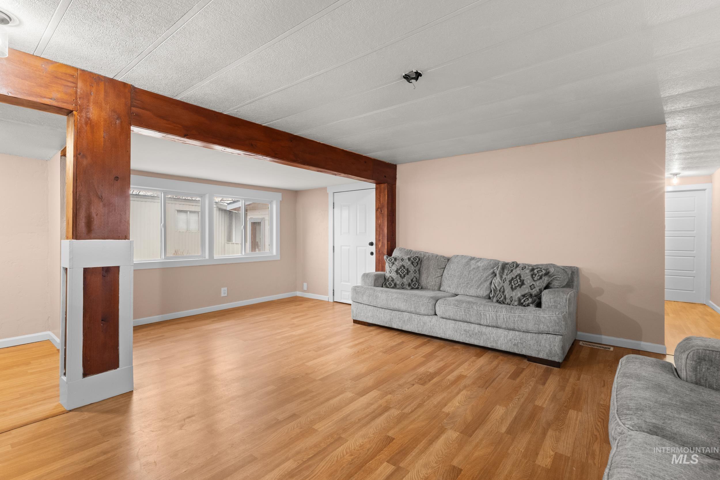 Living room with light wood-style flooring and a textured ceiling