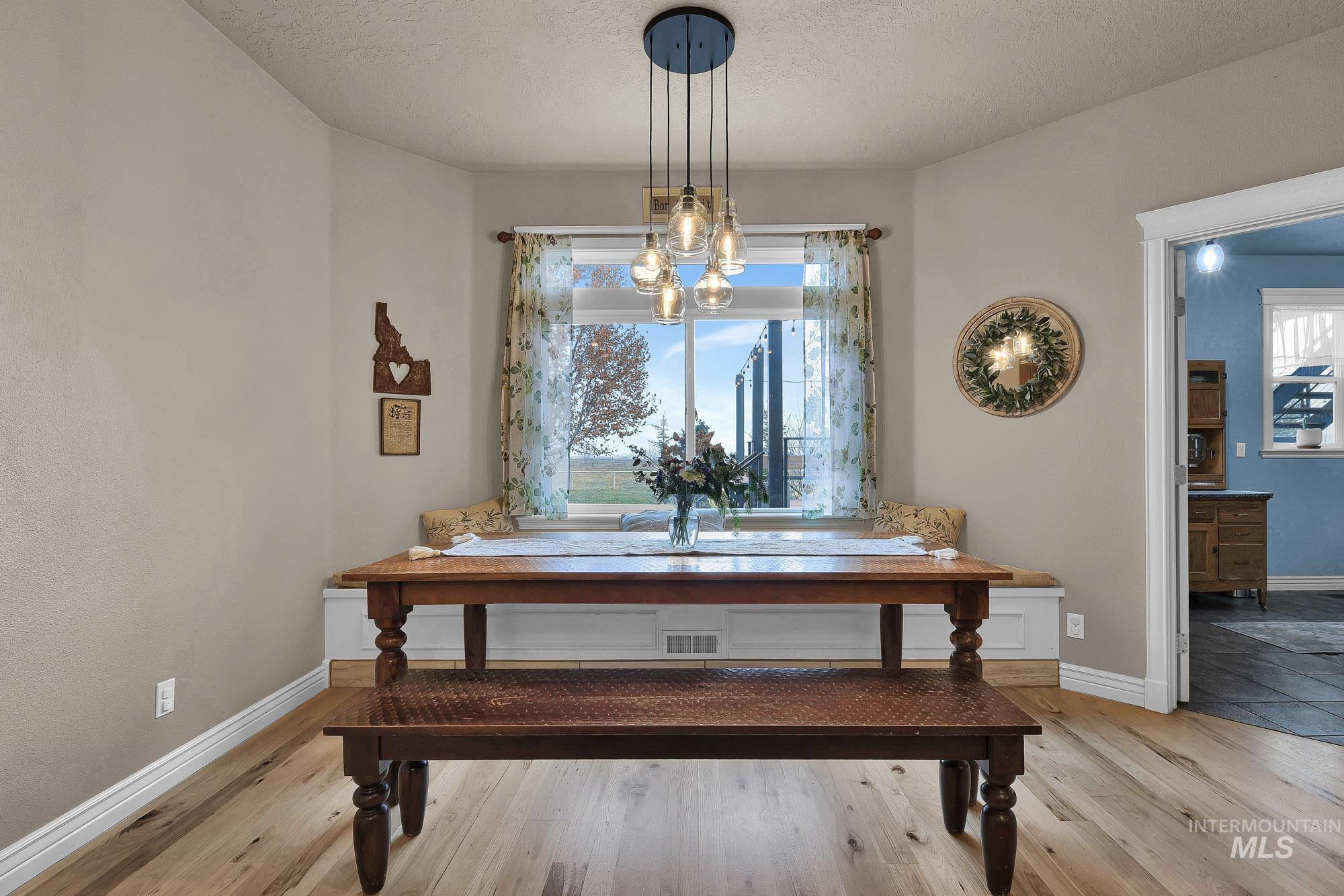 Dining nook featuring light Maple flooring and a built in bench with storage