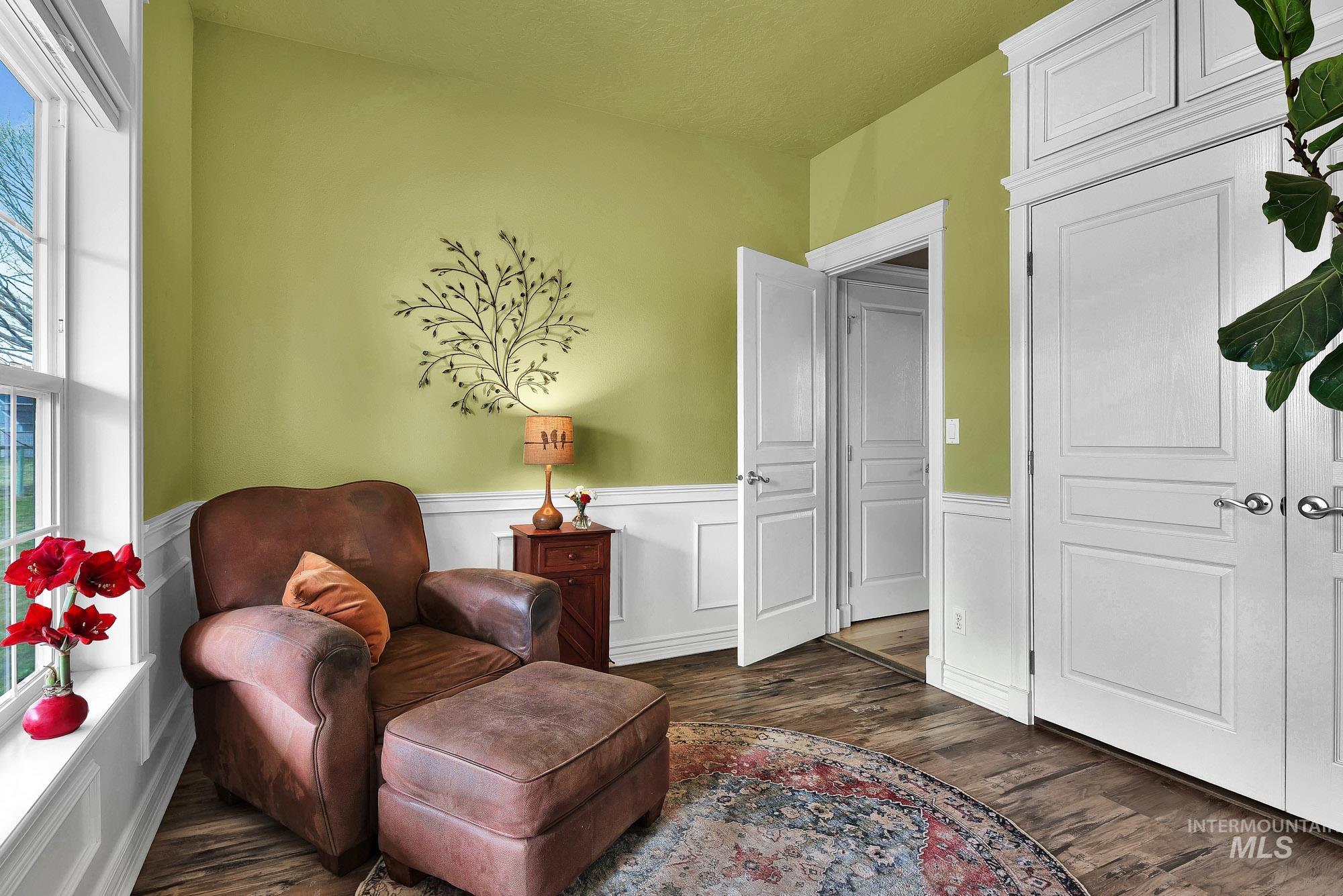 Office/ den area with a wainscoted wall and engineered wood-style flooring