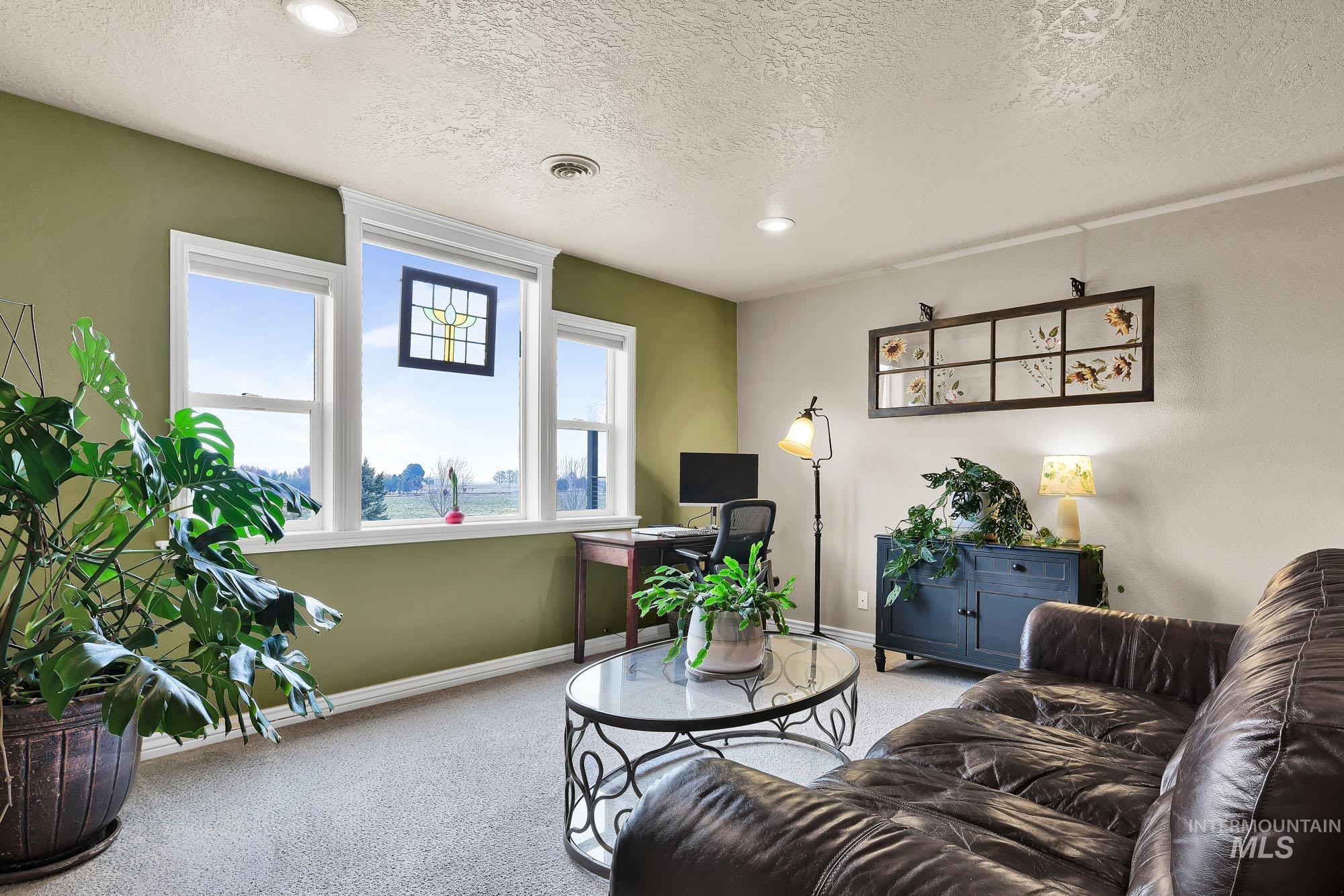 Loft/ Bonus area with an office area, a large window view of the mountains, carpet flooring, and recessed lighting