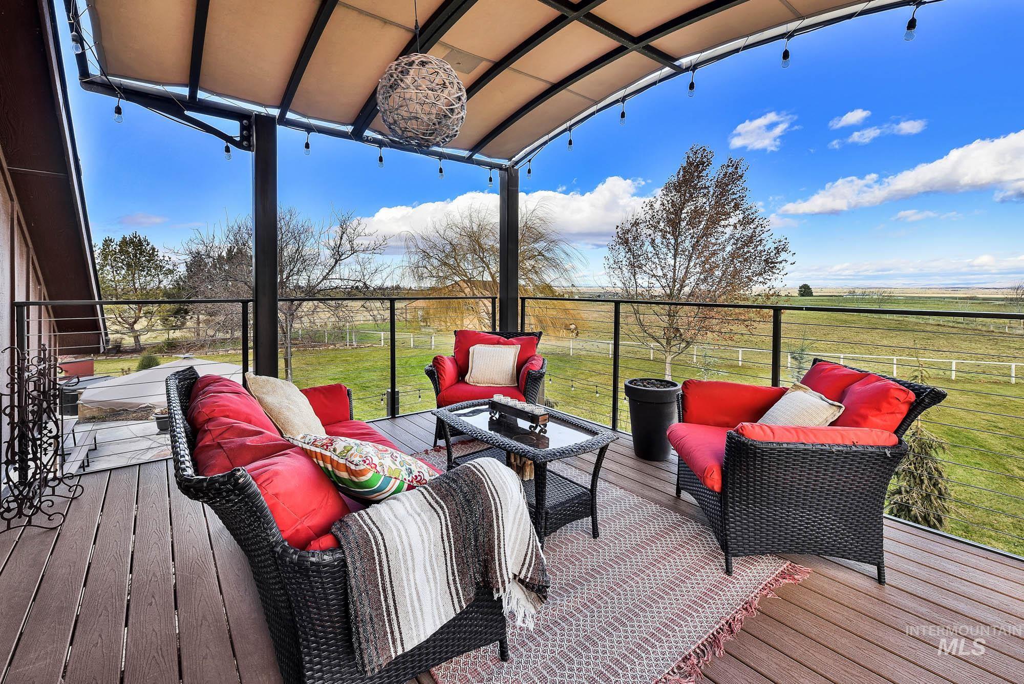 Deck with an outdoor gathering space and views  of the yard and the mountains