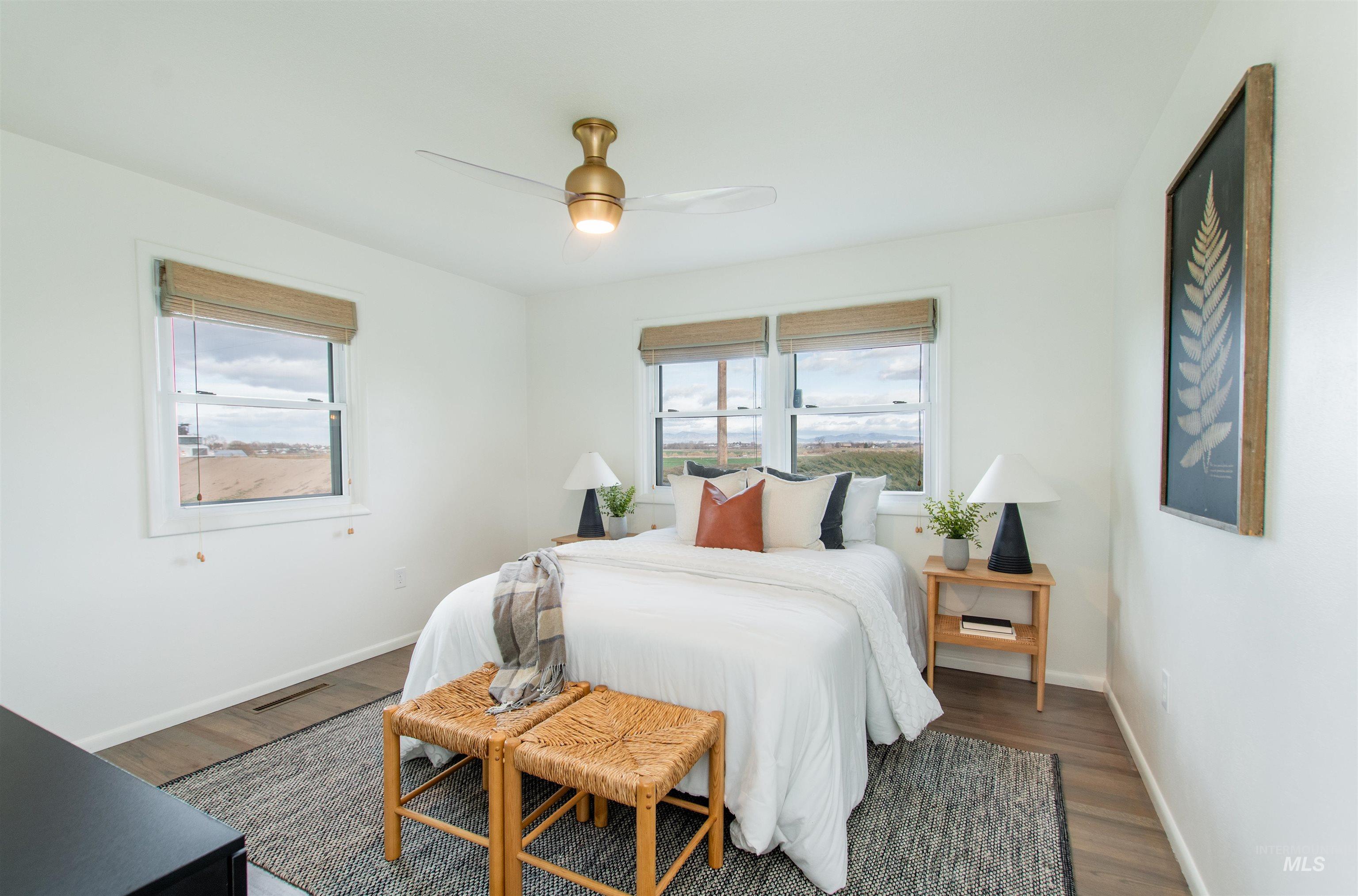 Bedroom featuring multiple windows, ceiling fan, and wood finished floors