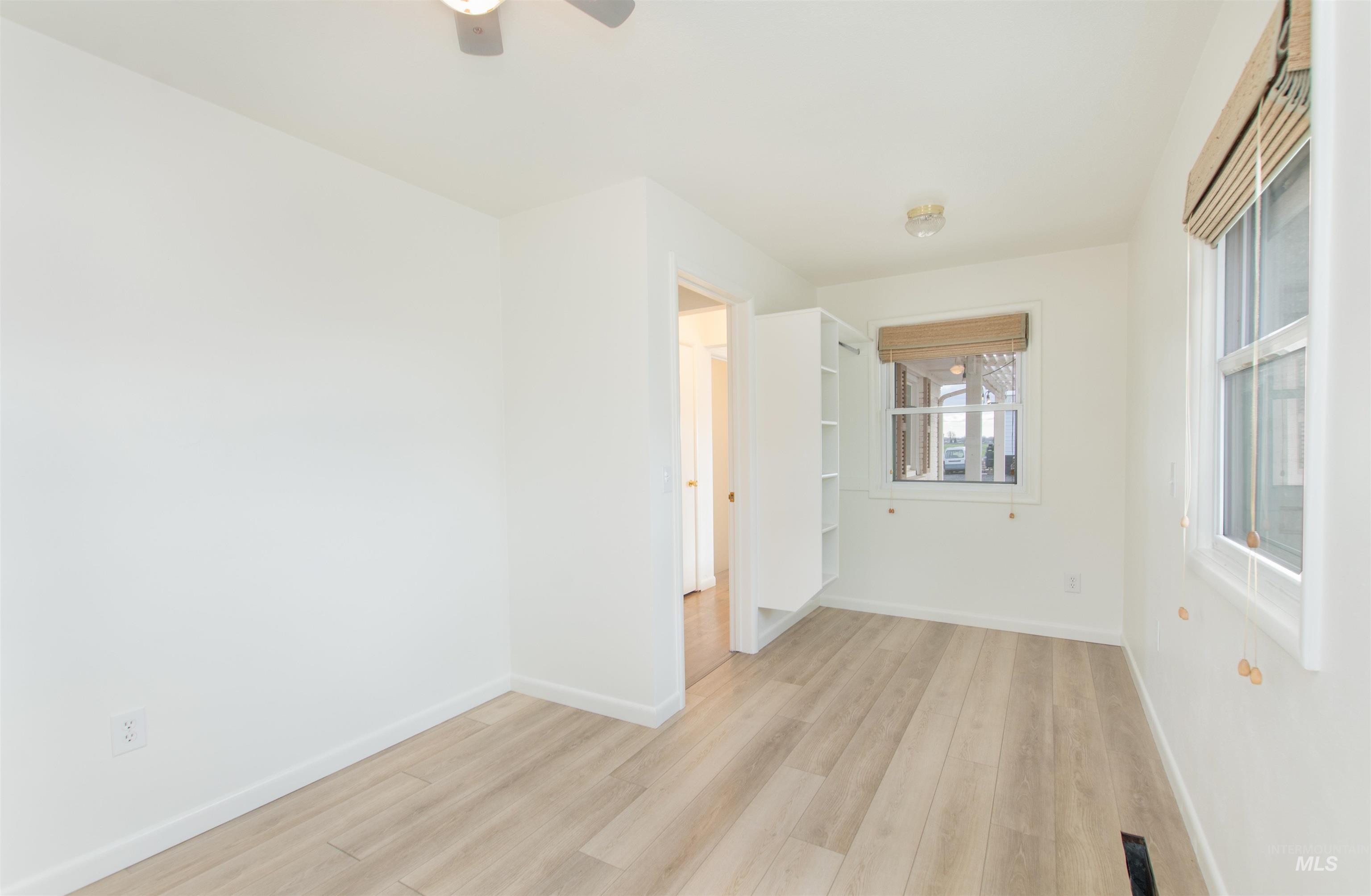 Unfurnished room with light wood-type flooring and a ceiling fan