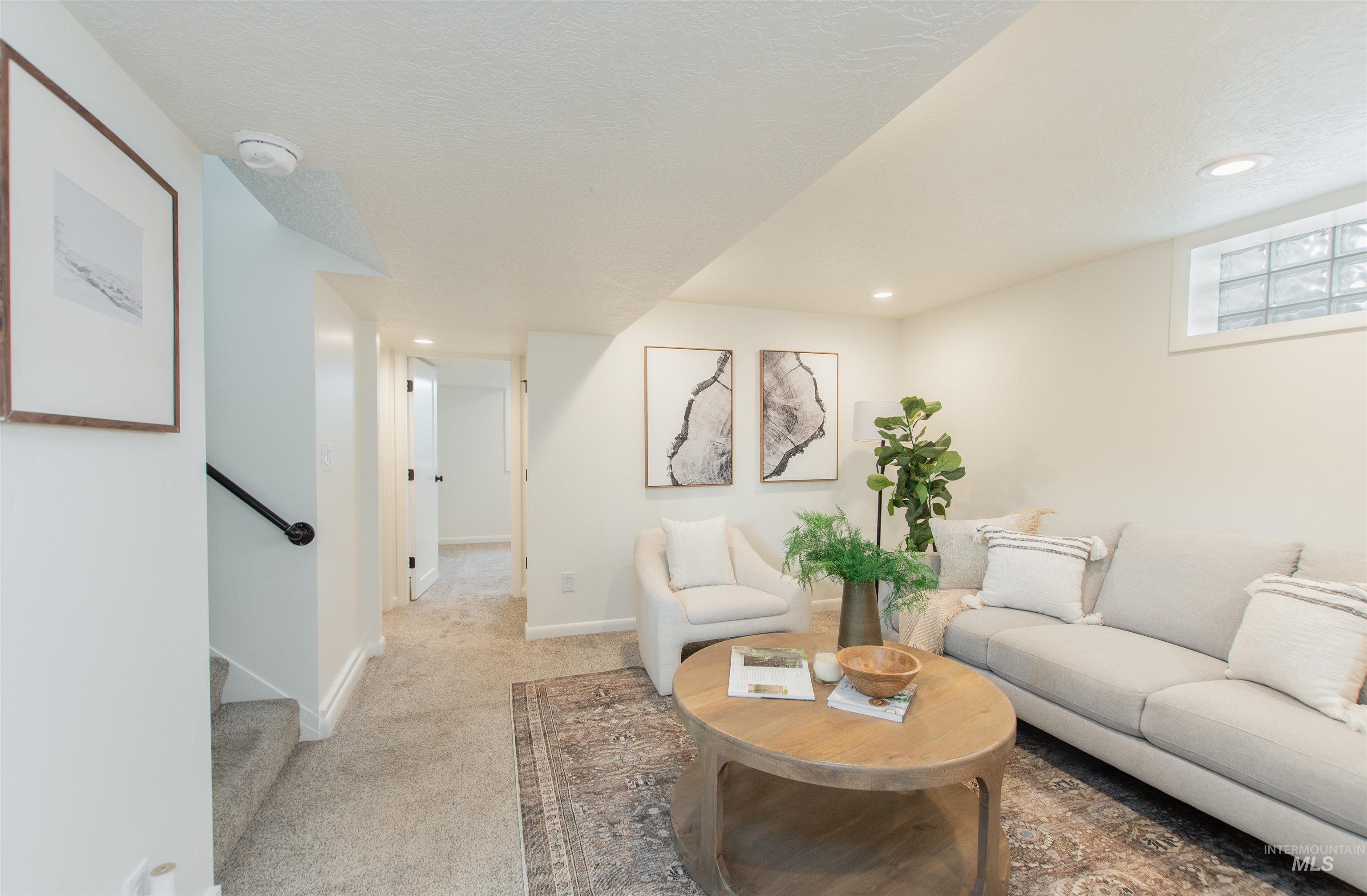 Carpeted living room featuring stairway, recessed lighting, and a textured ceiling