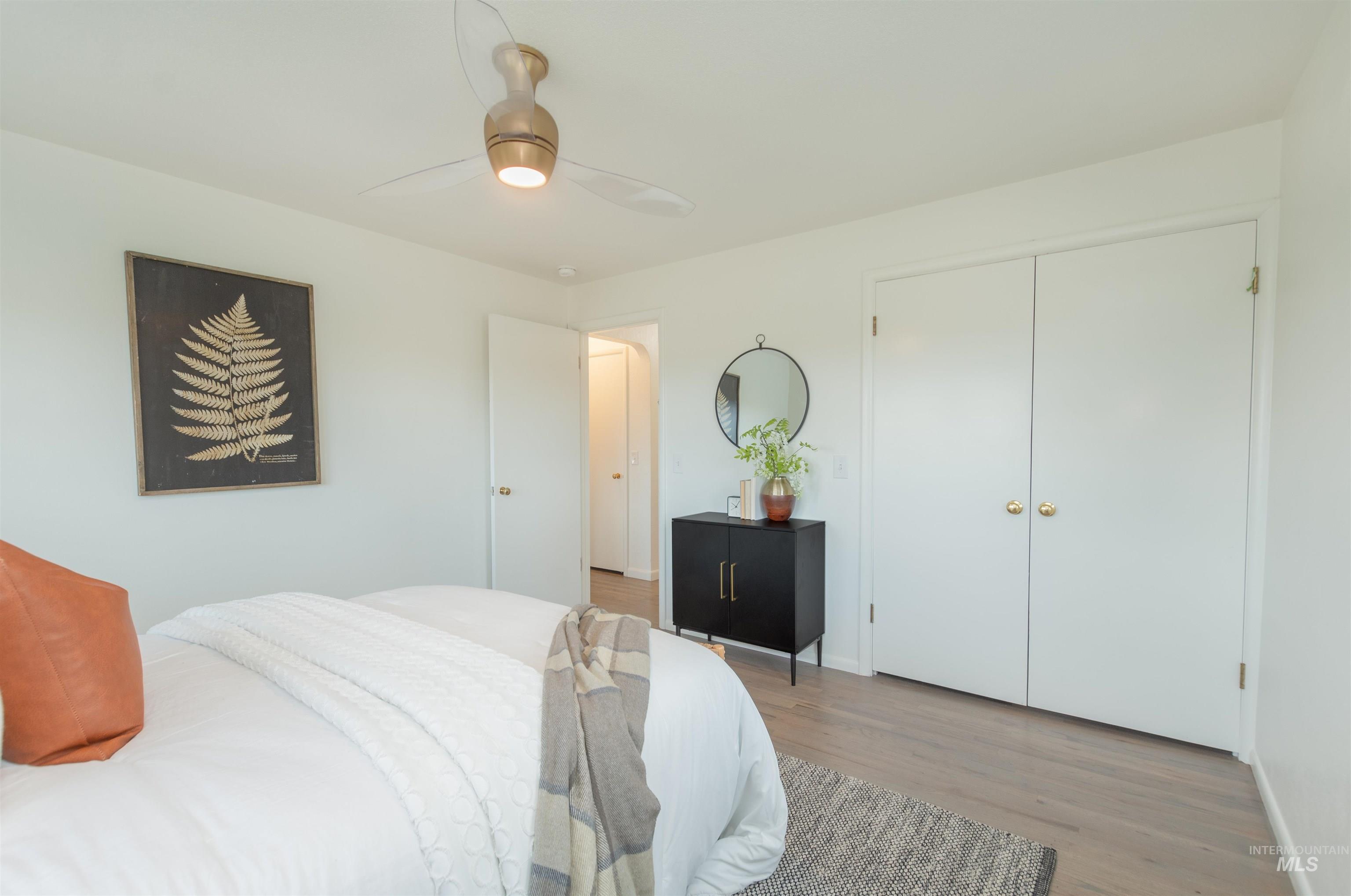 Bedroom featuring ceiling fan, wood finished floors, and a closet