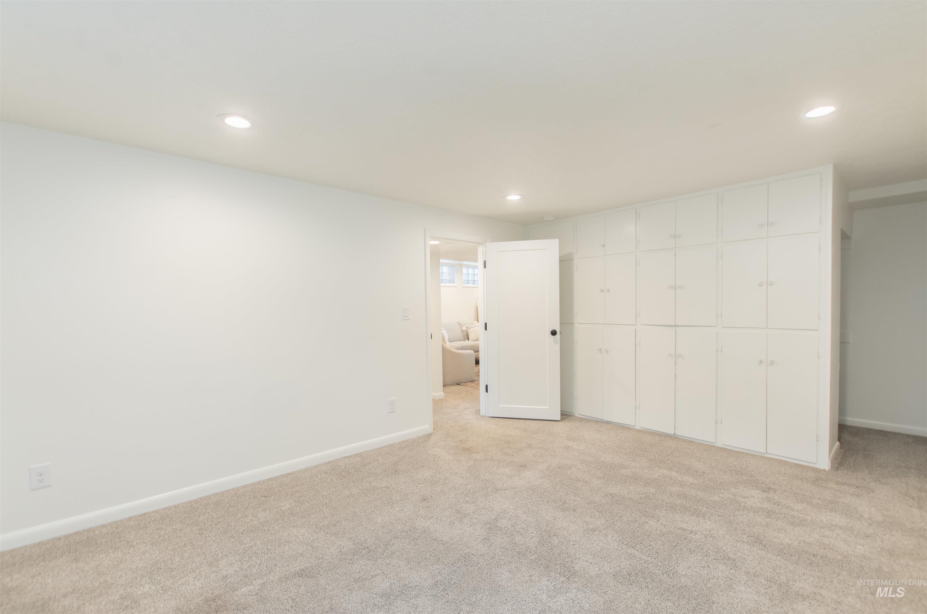 Unfurnished bedroom featuring light carpet and recessed lighting