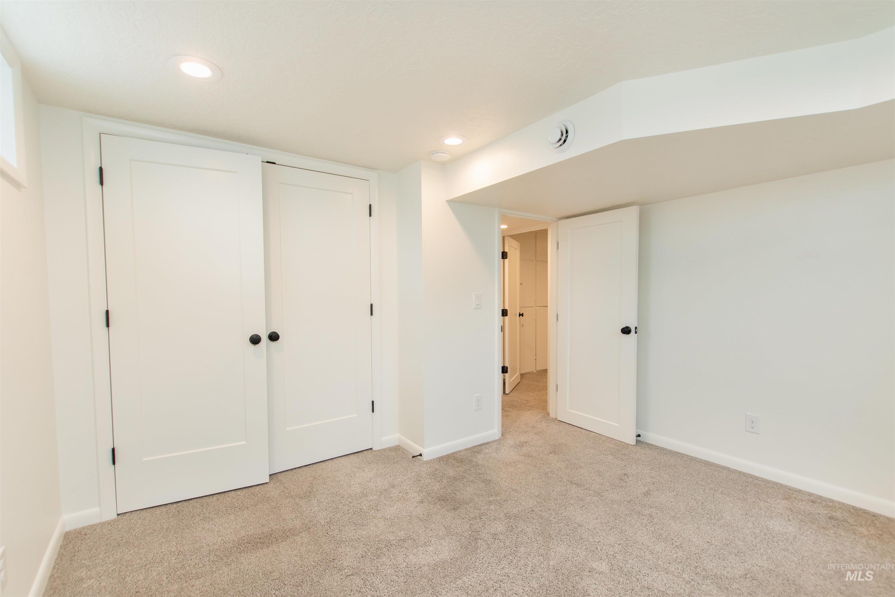Unfurnished bedroom with carpet, a closet, and recessed lighting