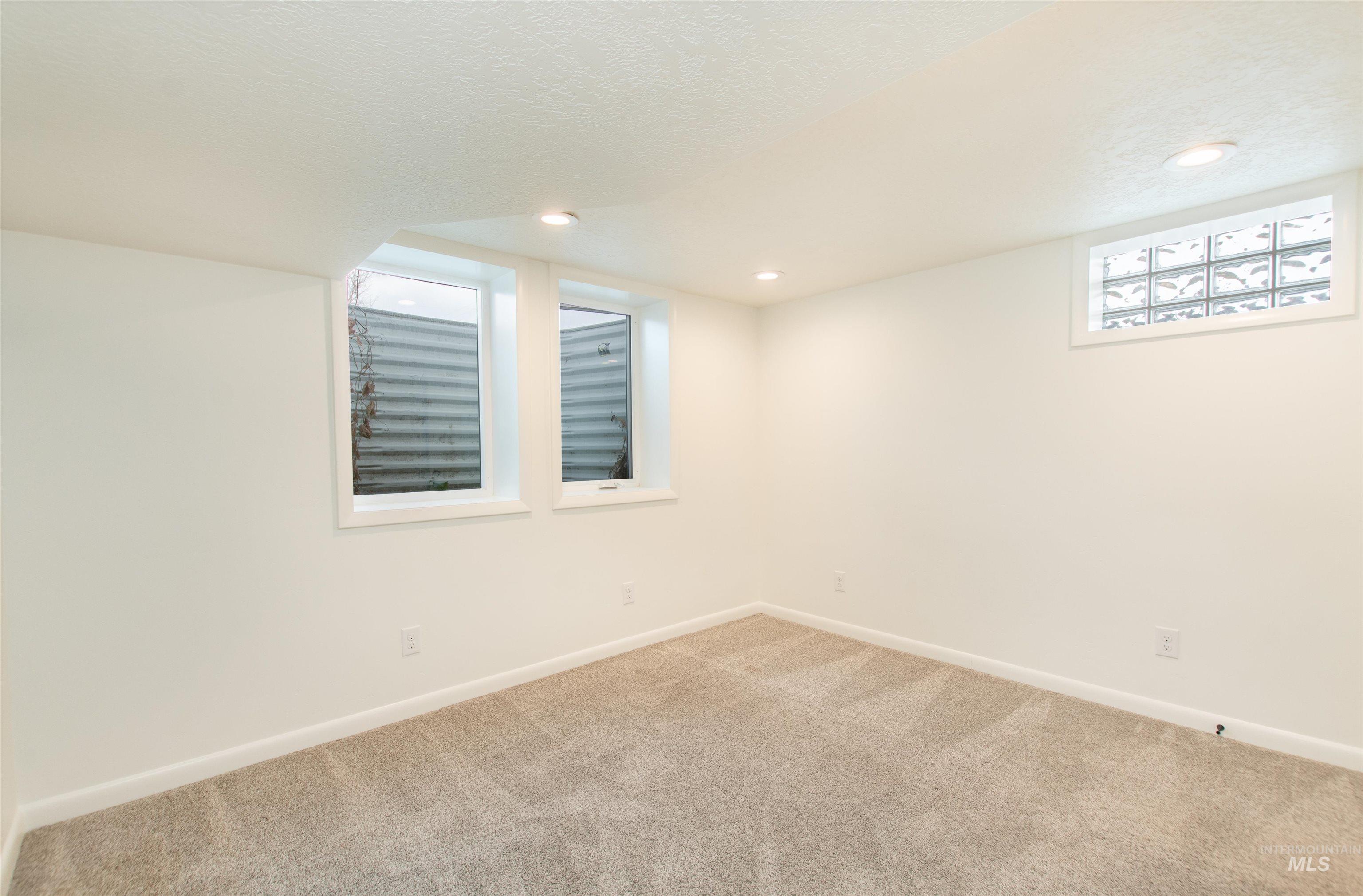 Carpeted spare room with recessed lighting