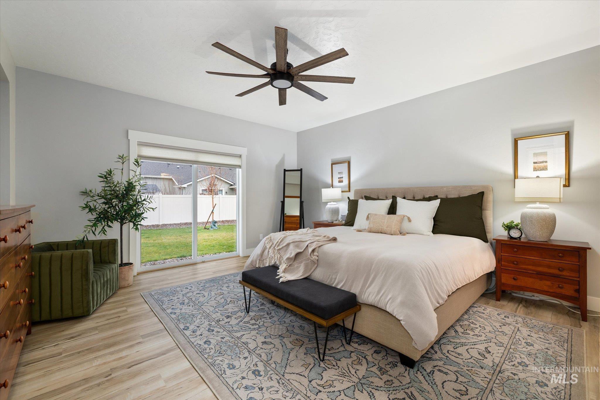 Main Bedroom featuring access to exterior patio, light wood-style floors, and a ceiling fan