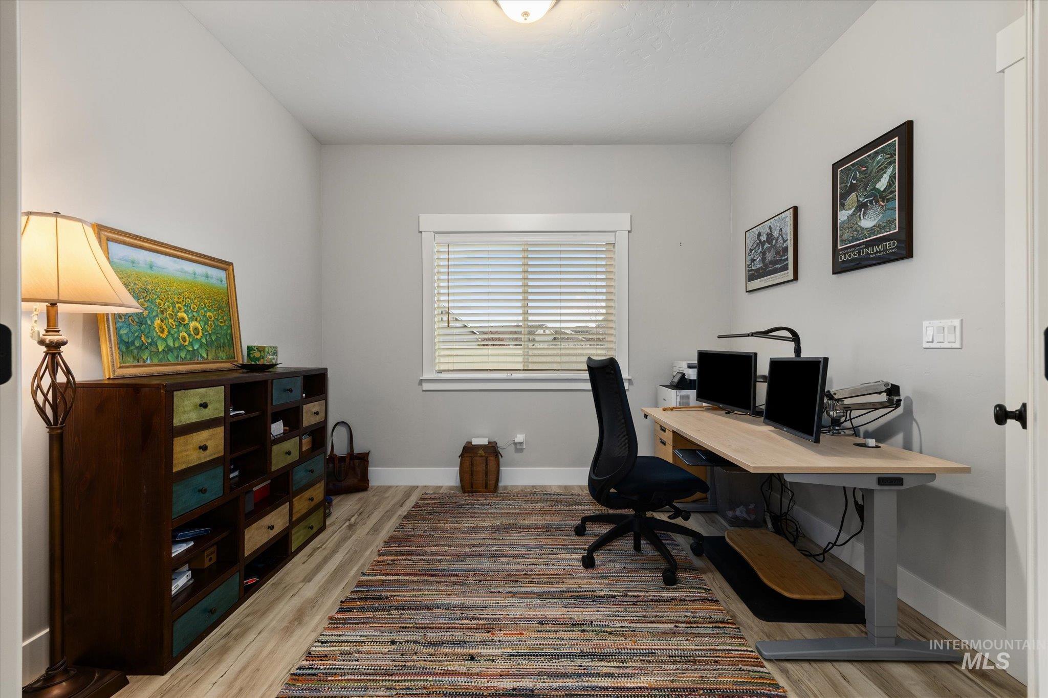 Office with light wood-style floors and baseboards