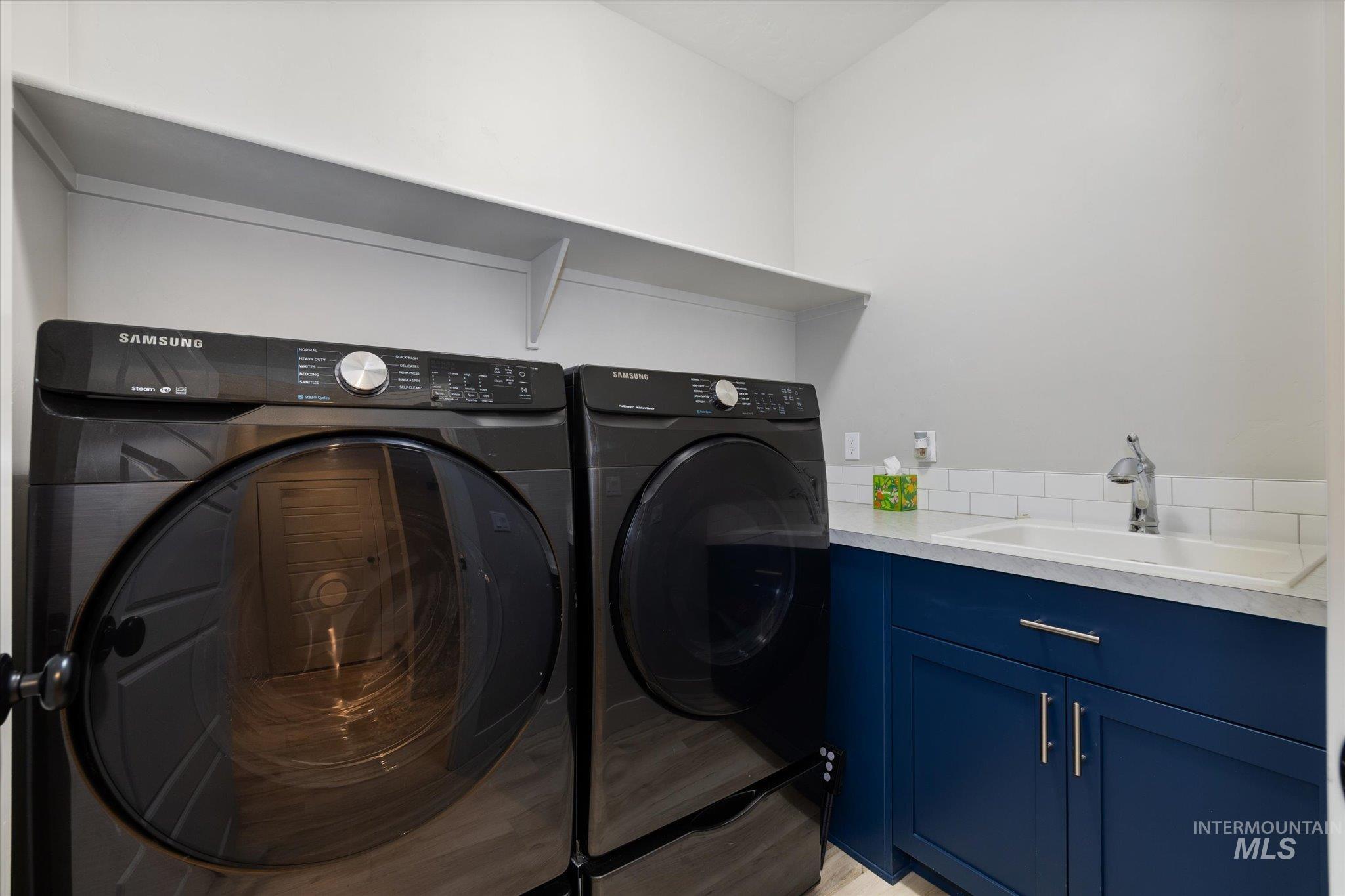 Main floor laundry with cabinets and sink.