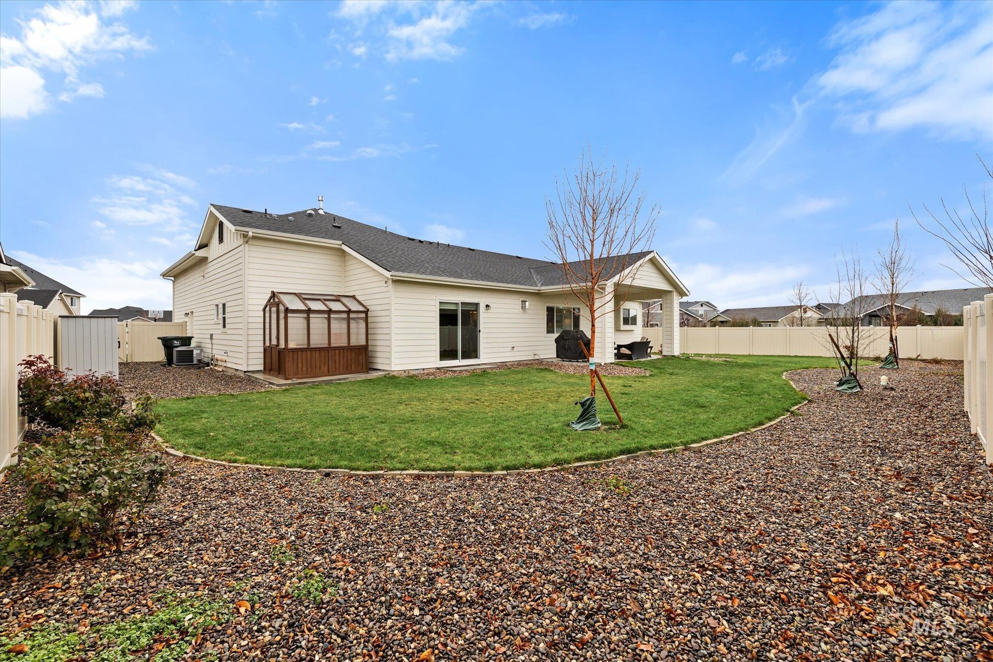 Rear view of house featuring a fenced backyard and a patio