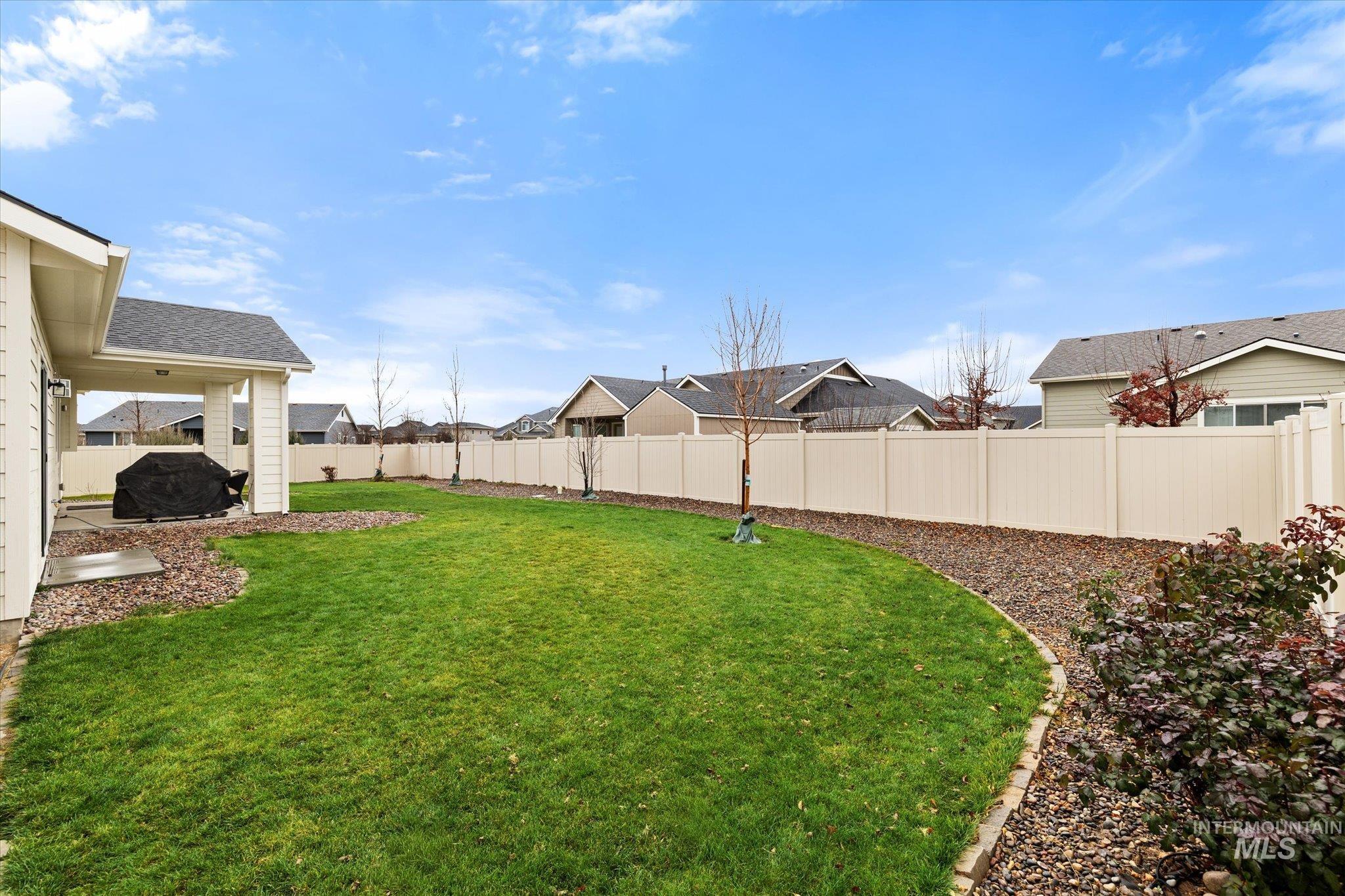 Fenced backyard featuring a residential view