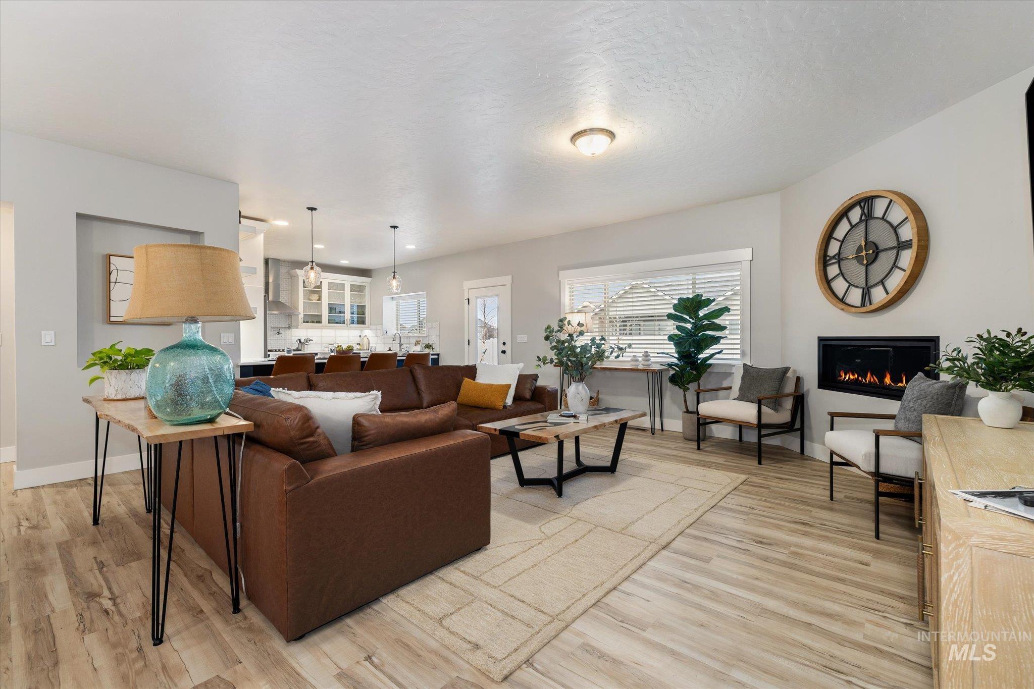 Living room featuring a glass covered fireplace and light wood-style floors