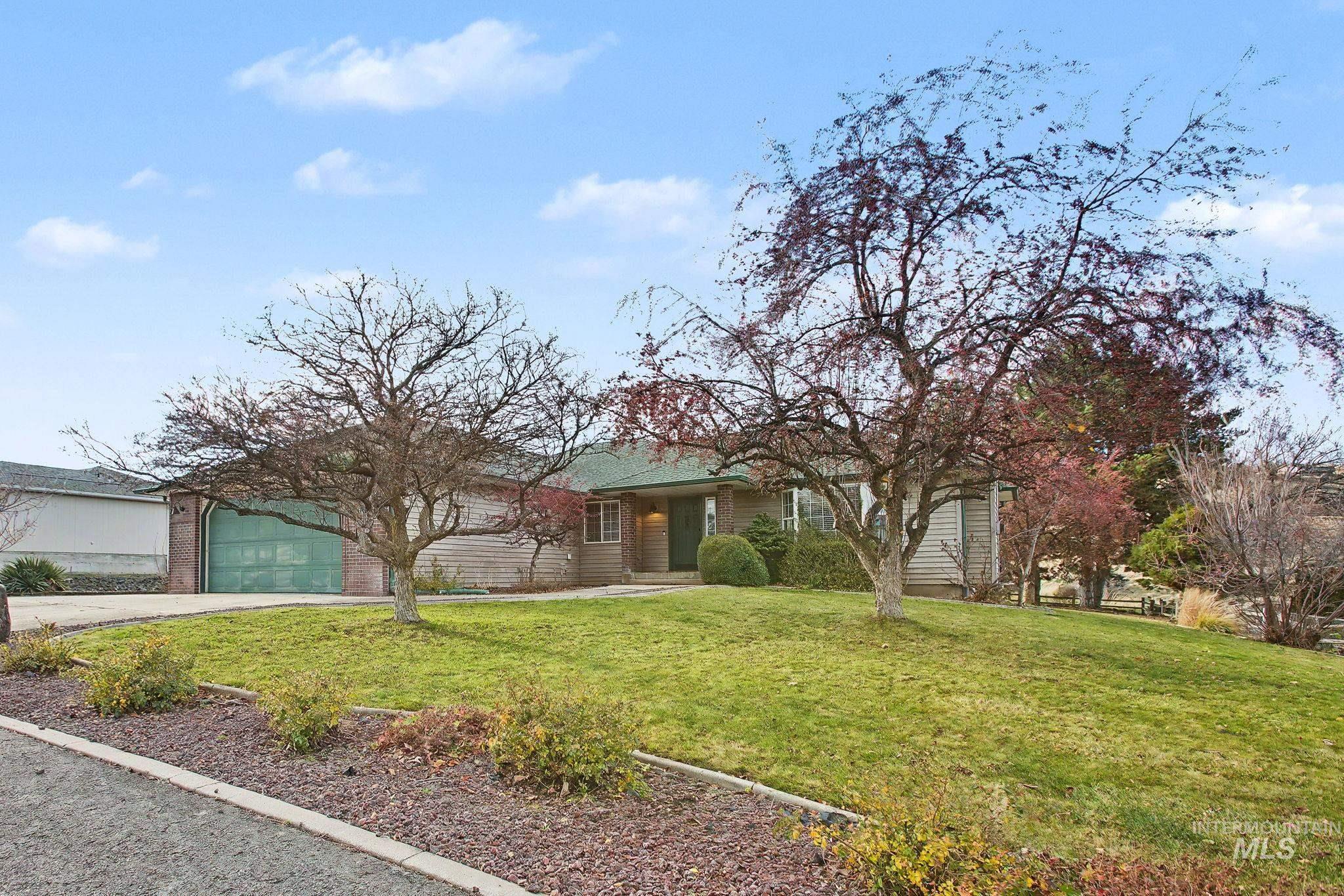 View of front of property featuring a front lawn, concrete driveway, and a garage
