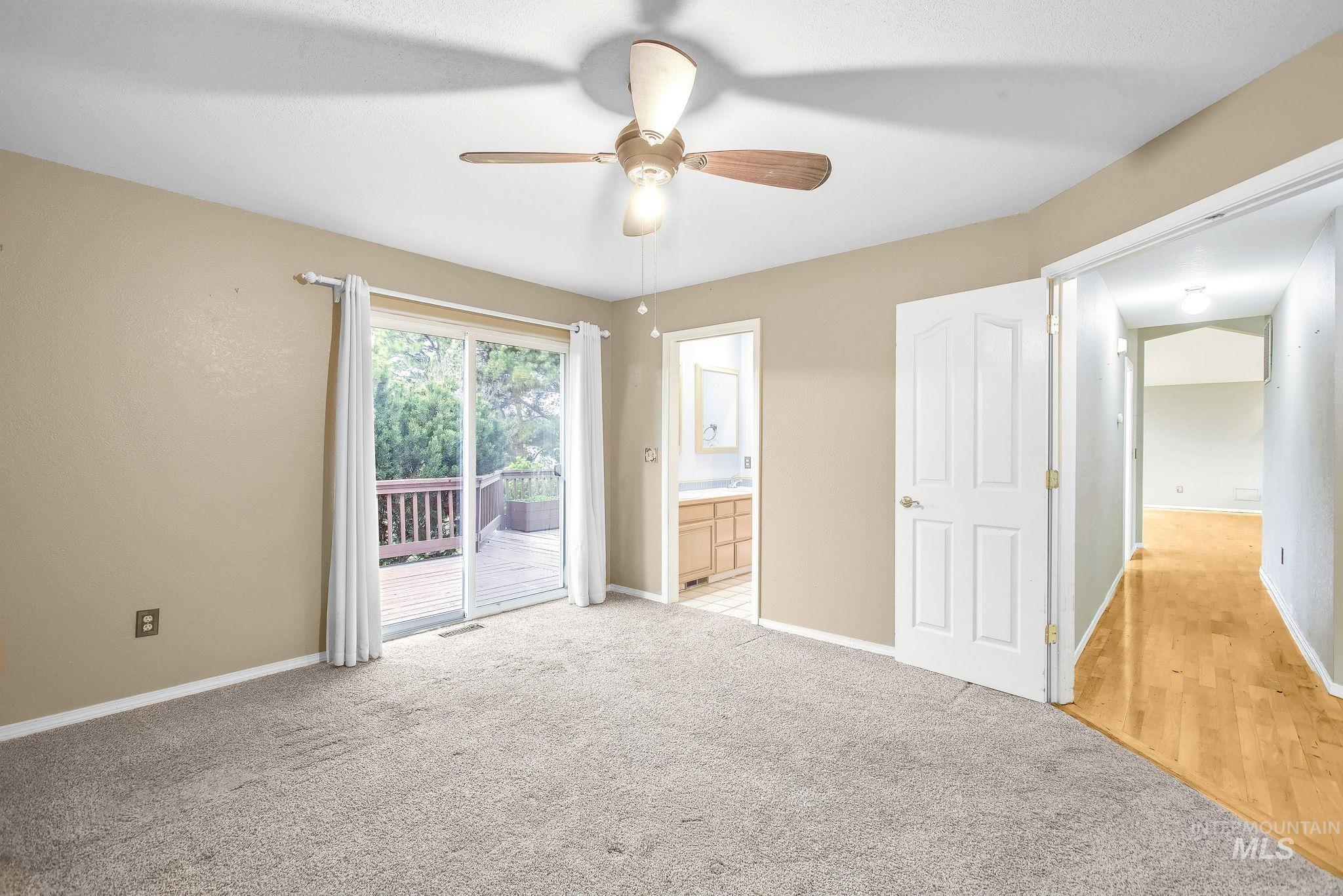 Unfurnished bedroom with access to exterior, ensuite bath, carpet, and a ceiling fan