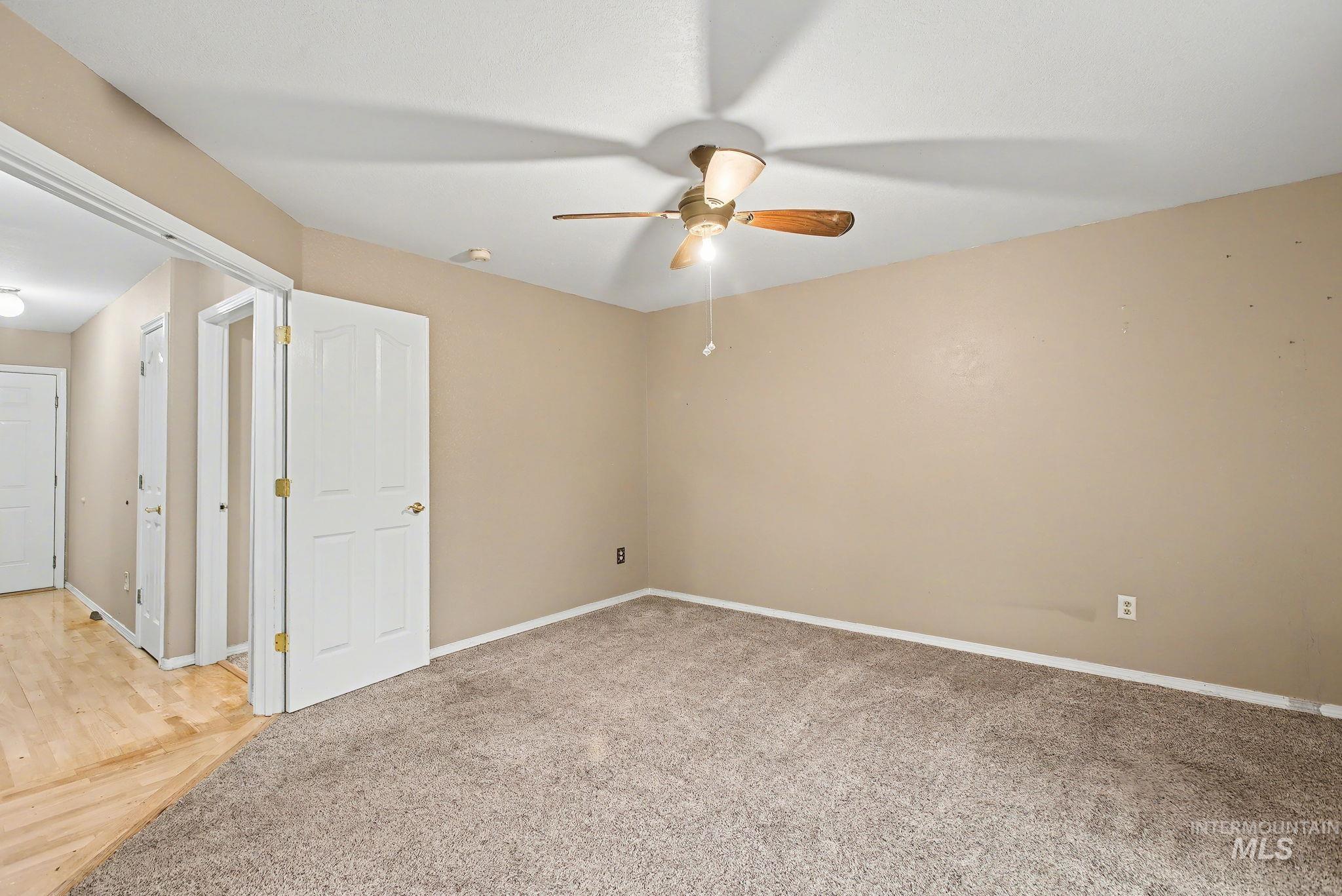 Unfurnished room featuring light colored carpet and ceiling fan