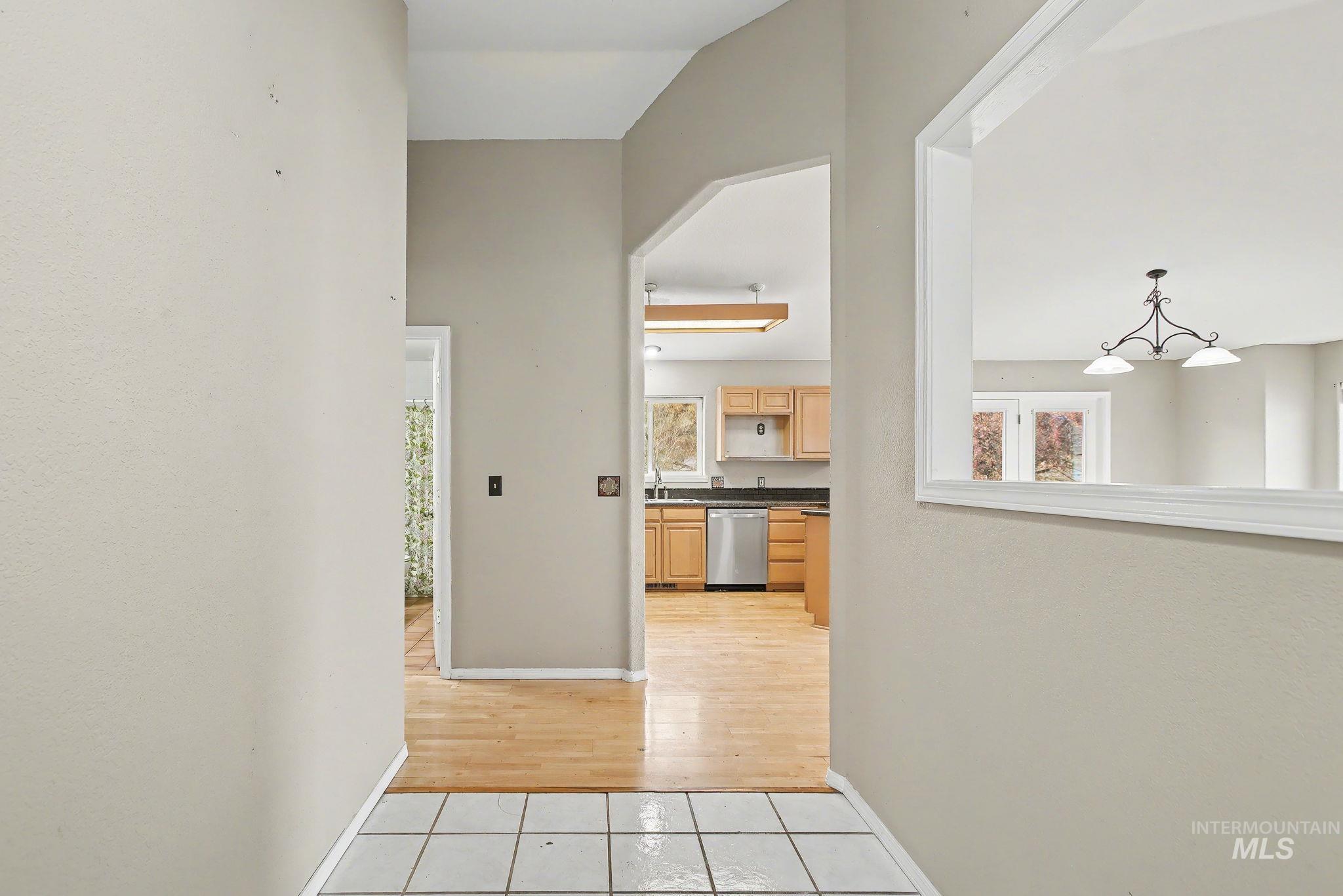 Hall featuring light tile patterned floors and a chandelier