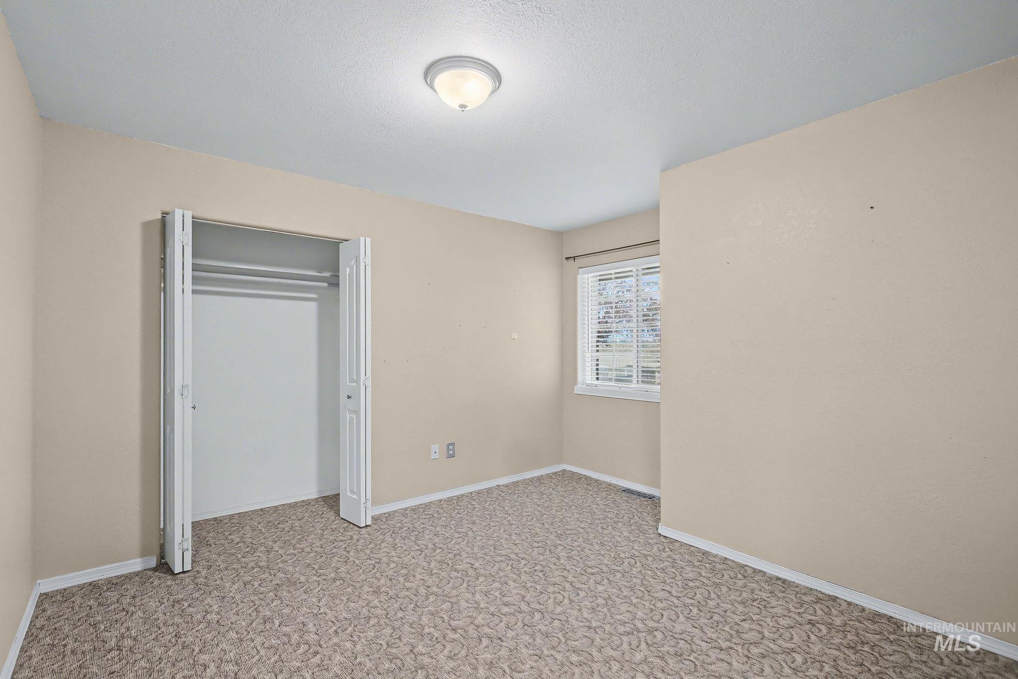 Unfurnished bedroom with a closet and light carpet