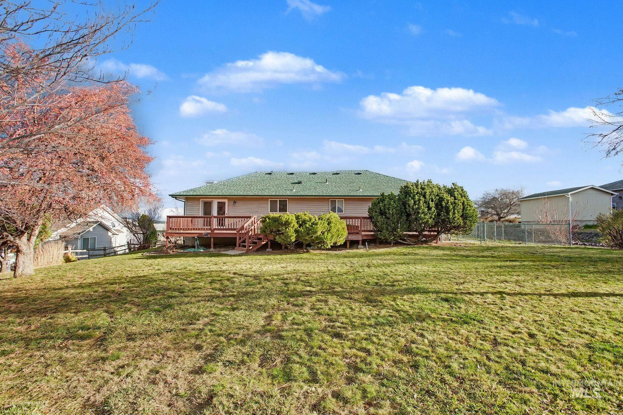 Back of house featuring a fenced backyard, a shingled roof, and a wooden deck