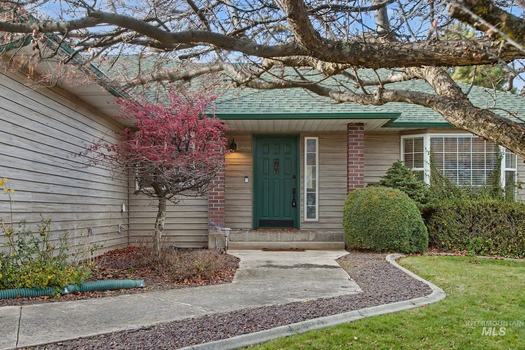 Entrance to property with roof with shingles and a yard