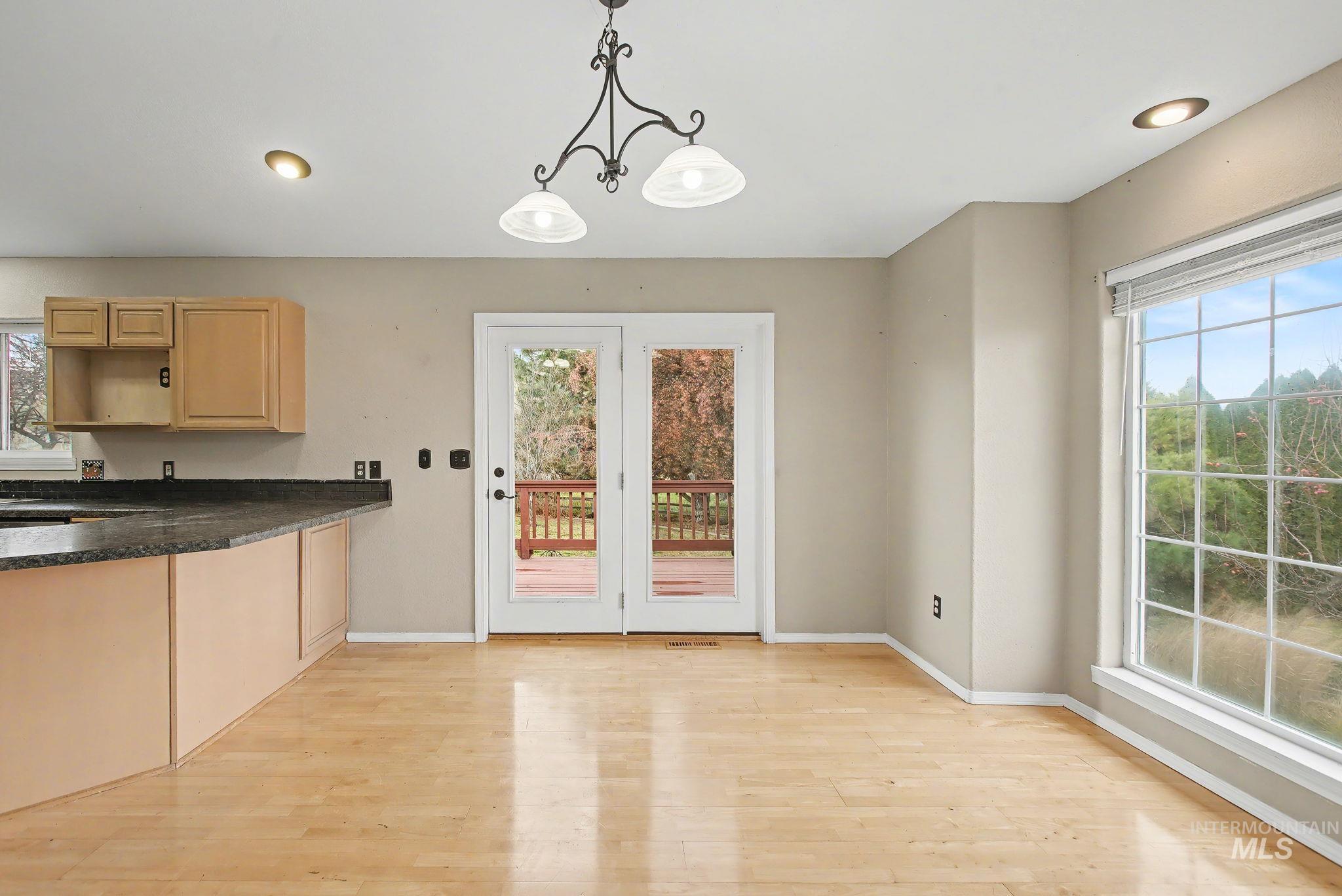 Kitchen with hanging light fixtures, light wood finished floors, light brown cabinets, and recessed lighting