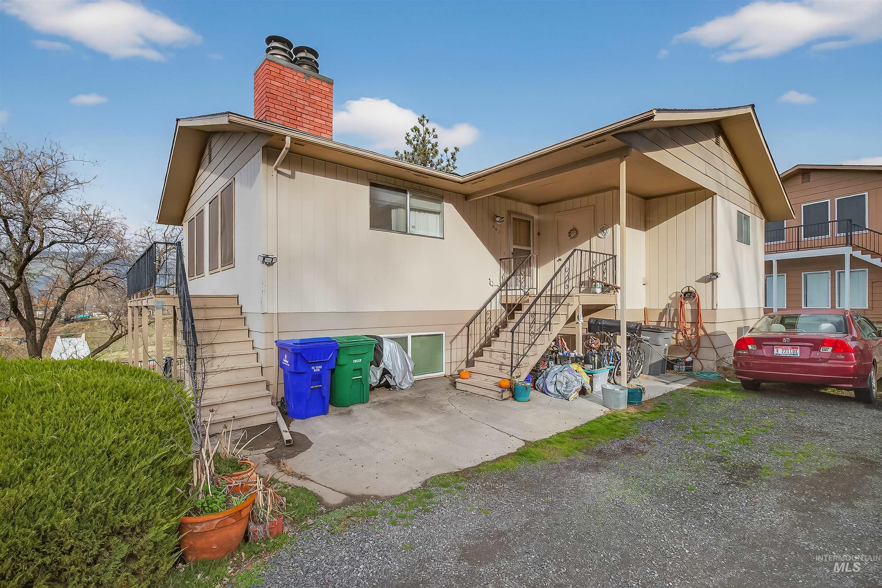 Rear view of property with stairs, a patio, and a chimney