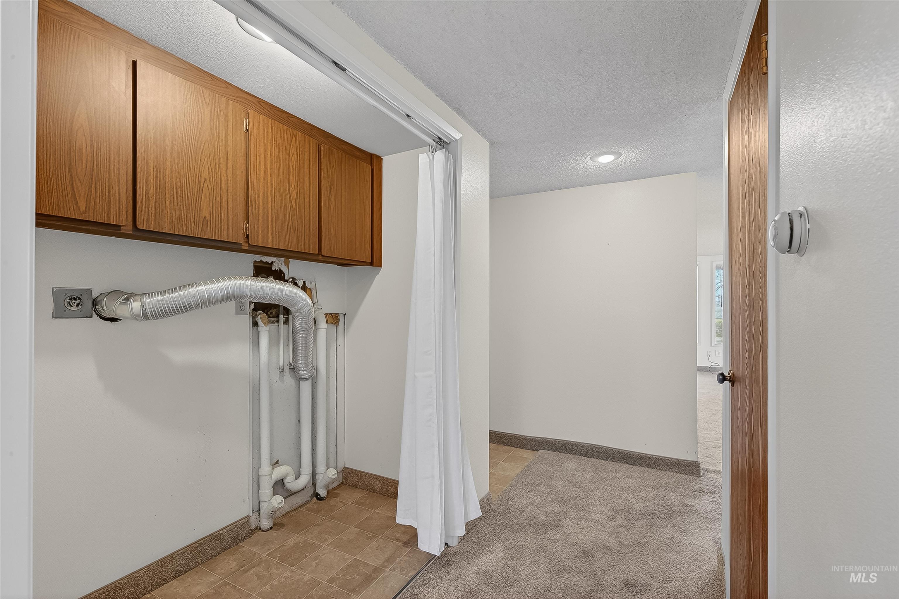Washroom featuring baseboards and a textured ceiling