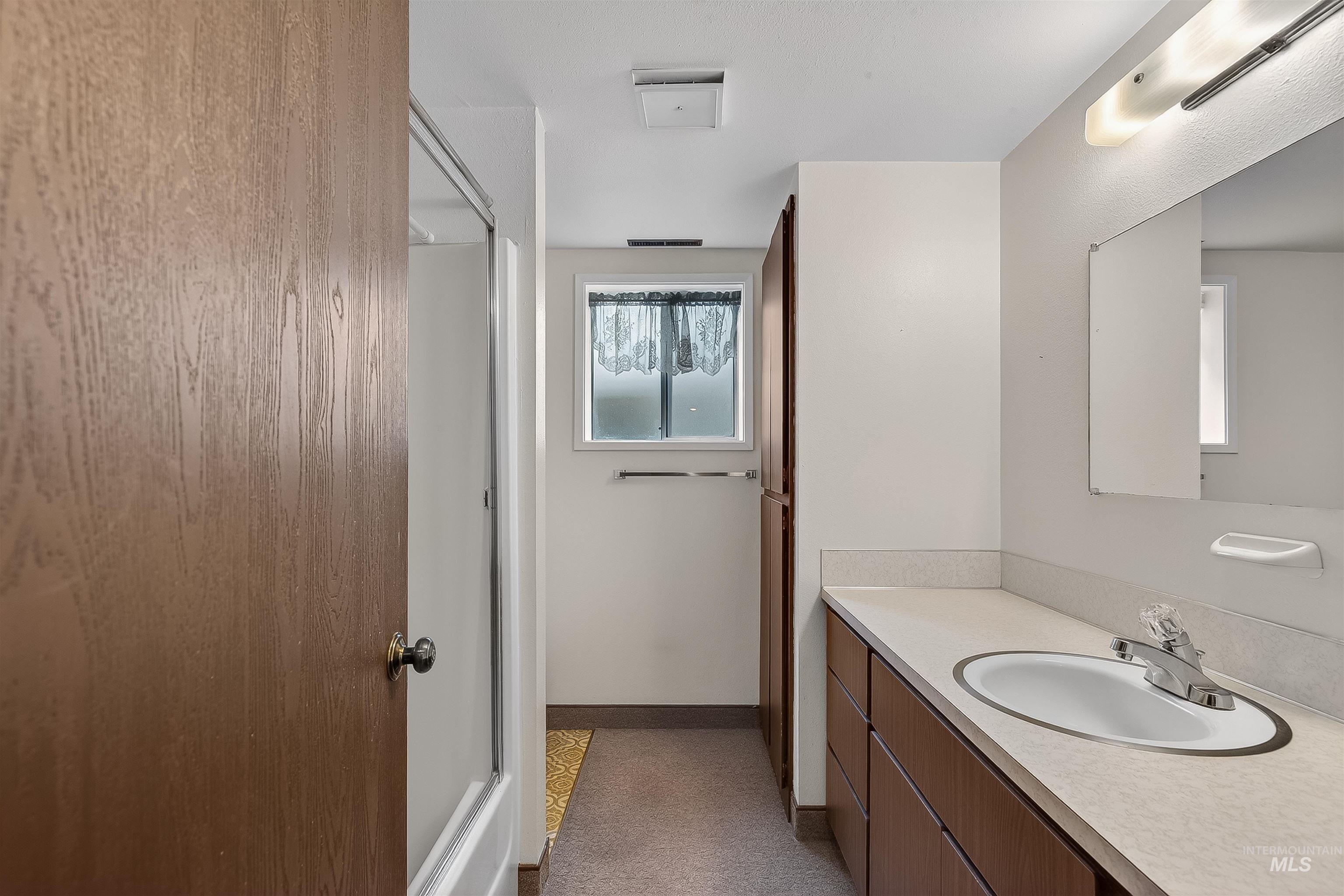 Bathroom featuring vanity and a shower