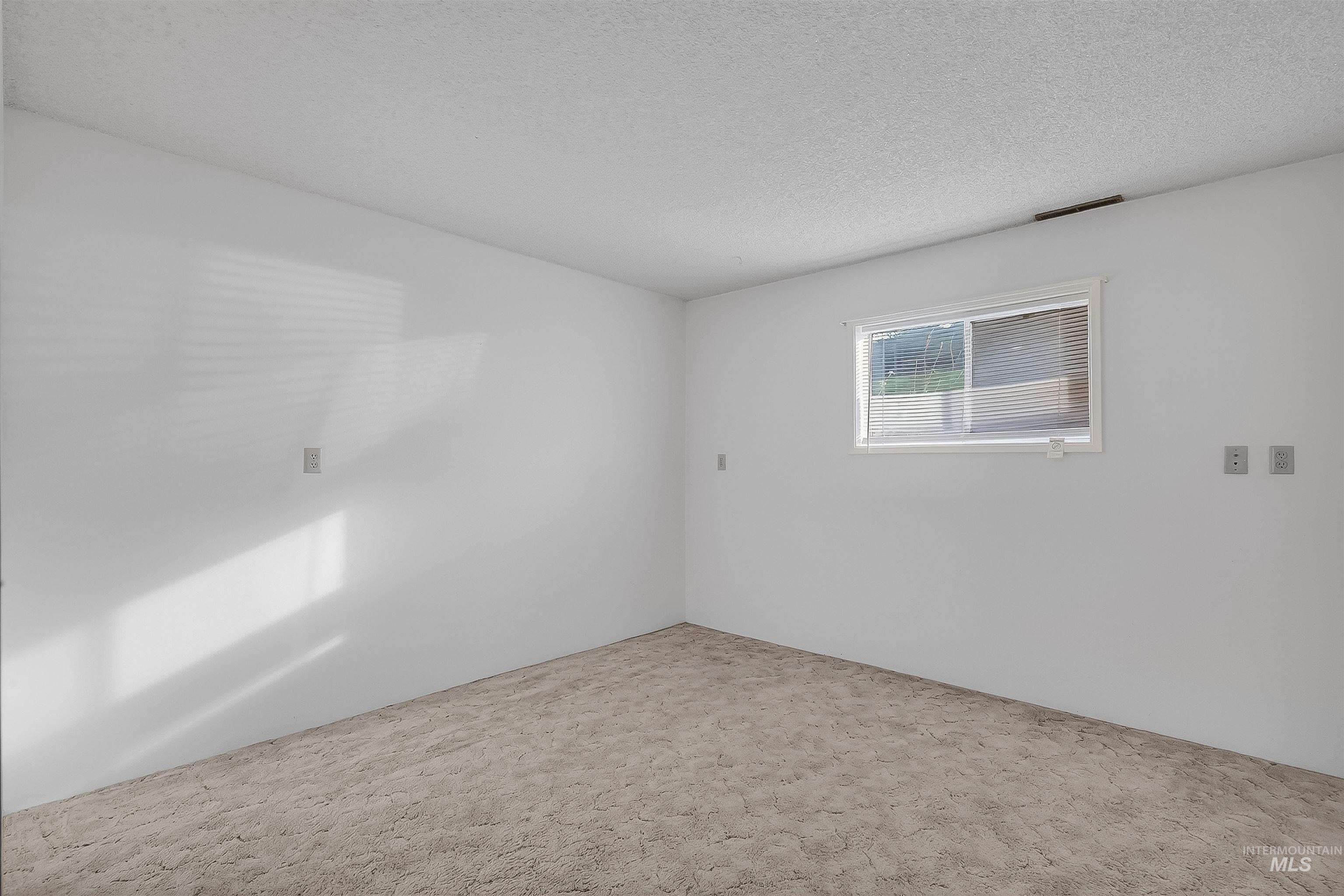 Carpeted empty room with a textured ceiling