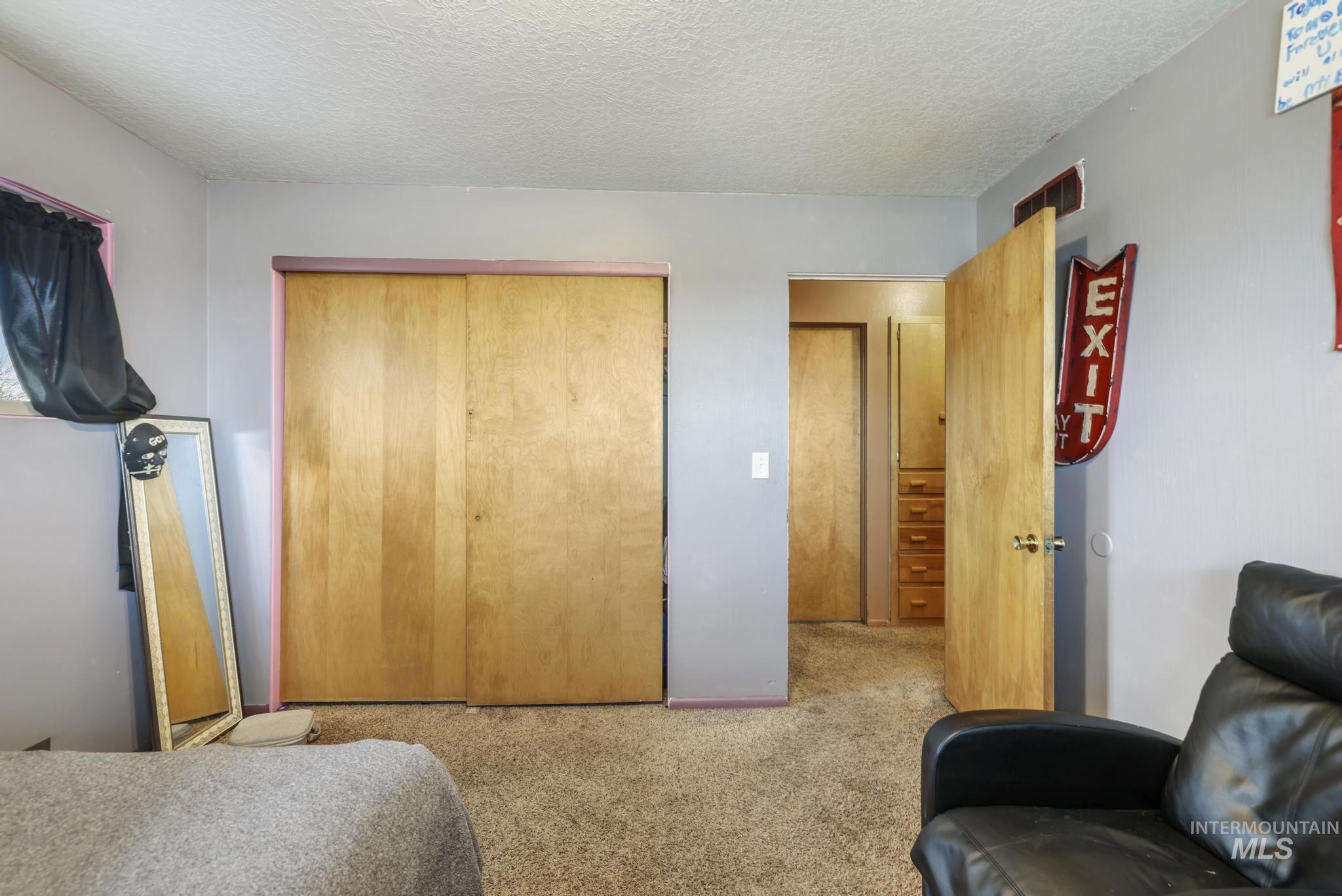 Bedroom featuring a closet, light carpet, and a textured ceiling