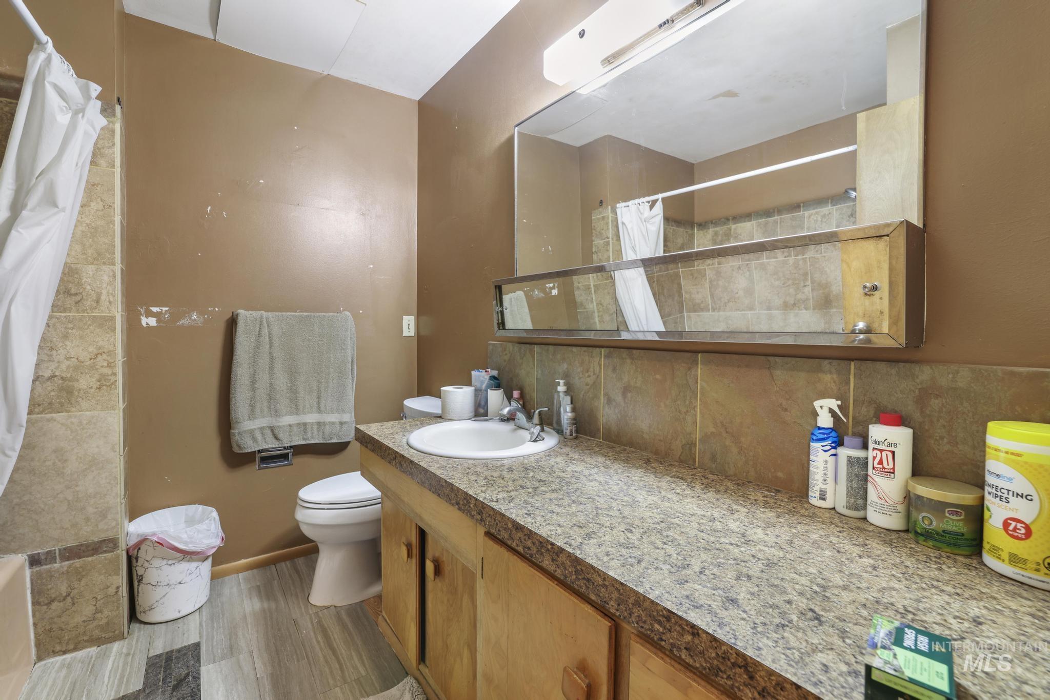 Bathroom with vanity, decorative backsplash, and a shower with shower curtain