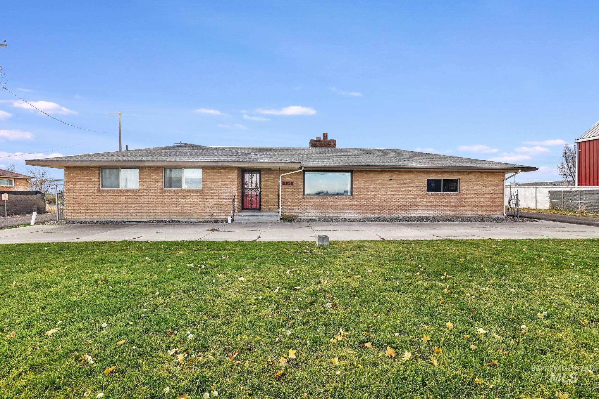 Ranch-style house with brick siding, a chimney, and a shingled roof