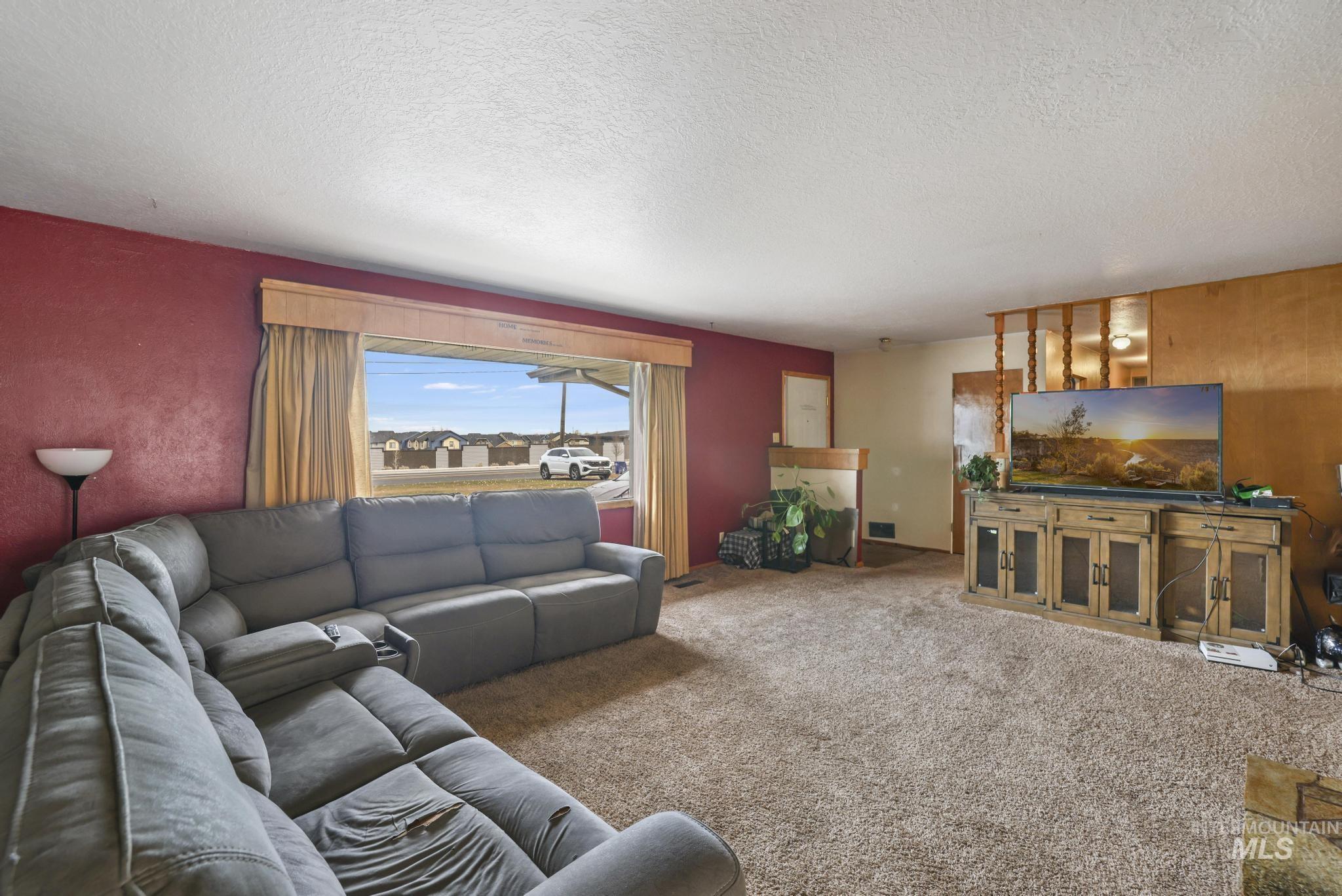 Carpeted living room featuring a textured ceiling