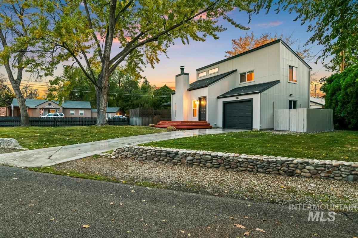 View of front facade featuring concrete driveway and a chimney