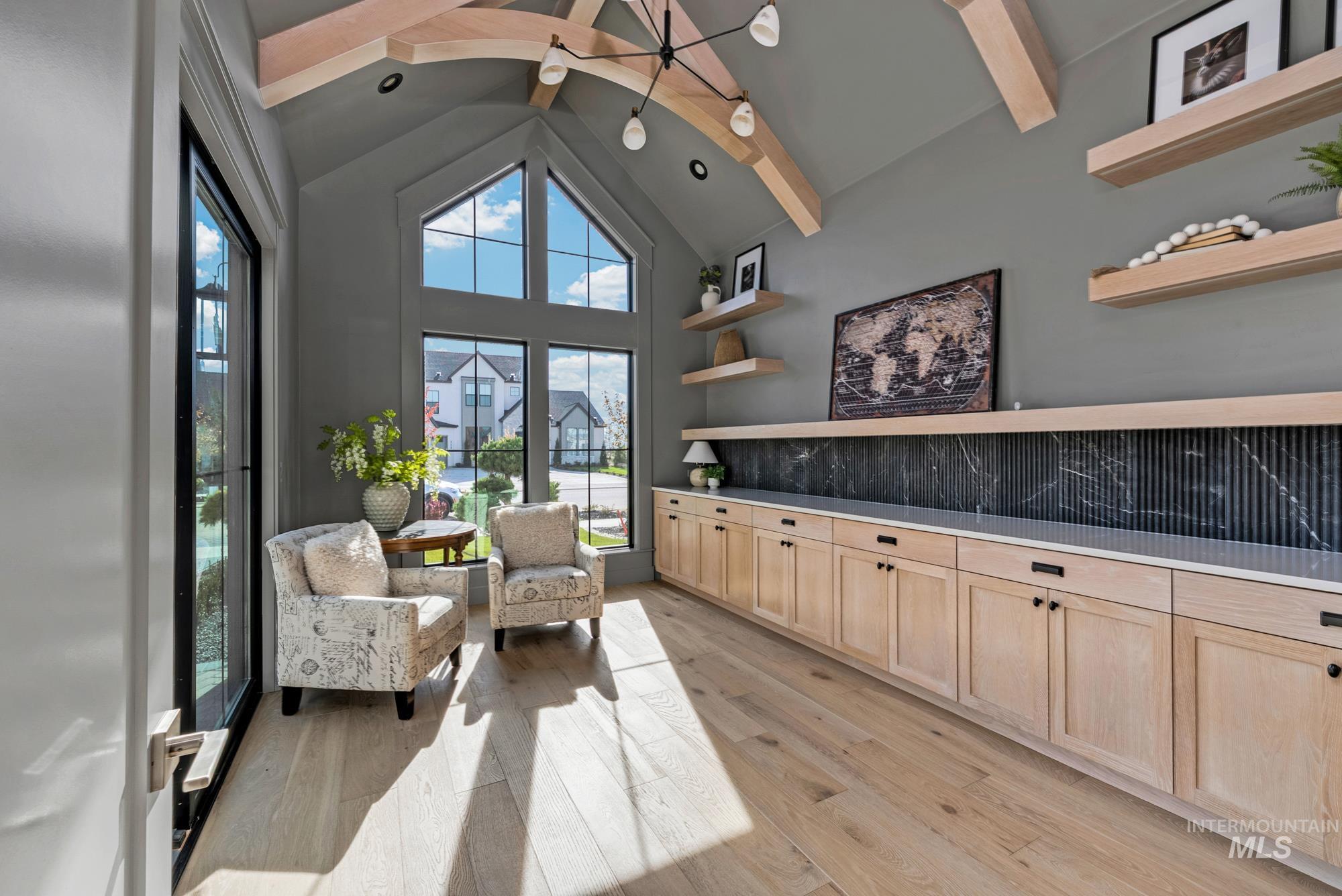 Living area with high vaulted ceiling, beamed ceiling, and light wood-type flooring