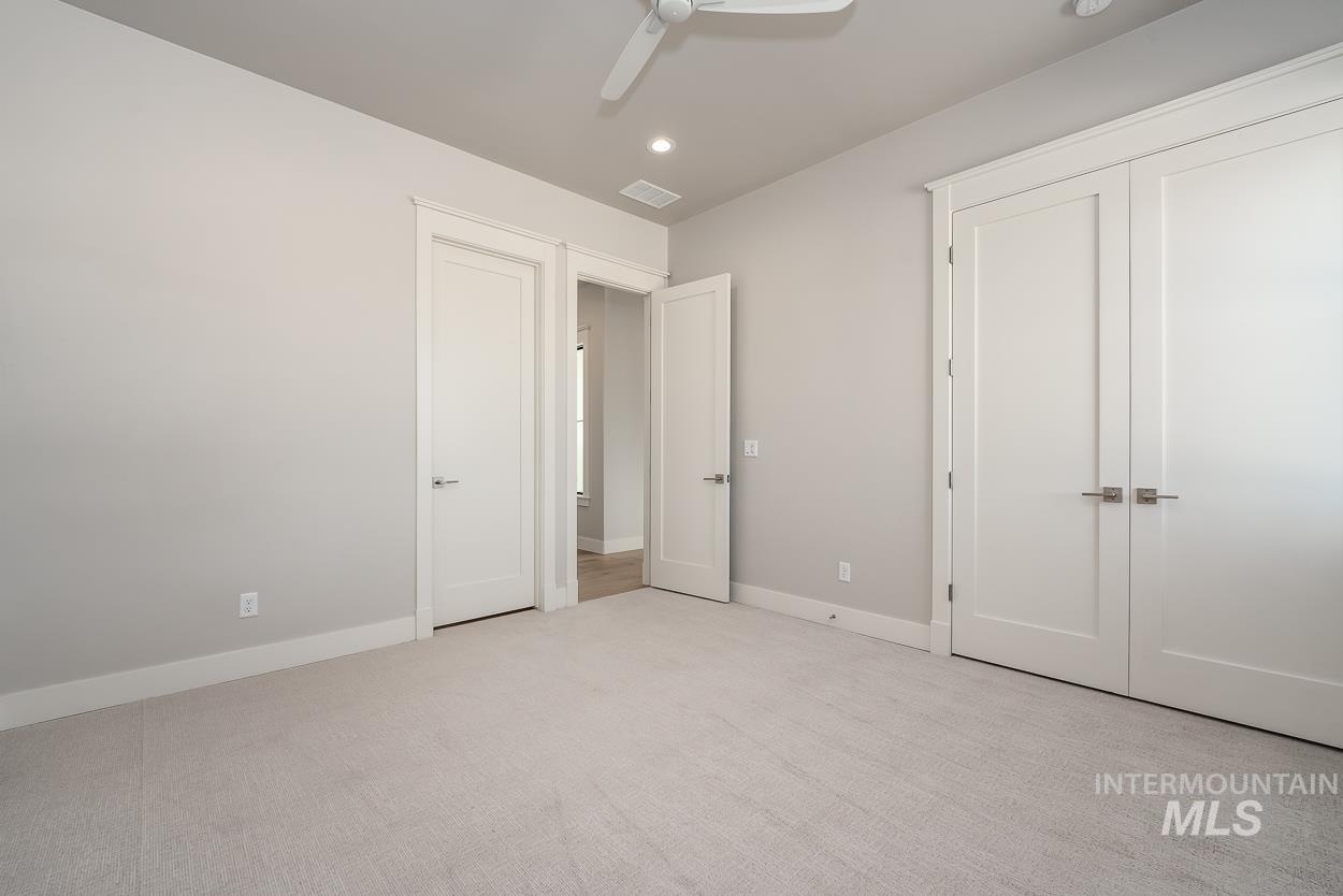 Unfurnished bedroom featuring recessed lighting, light carpet, and a ceiling fan