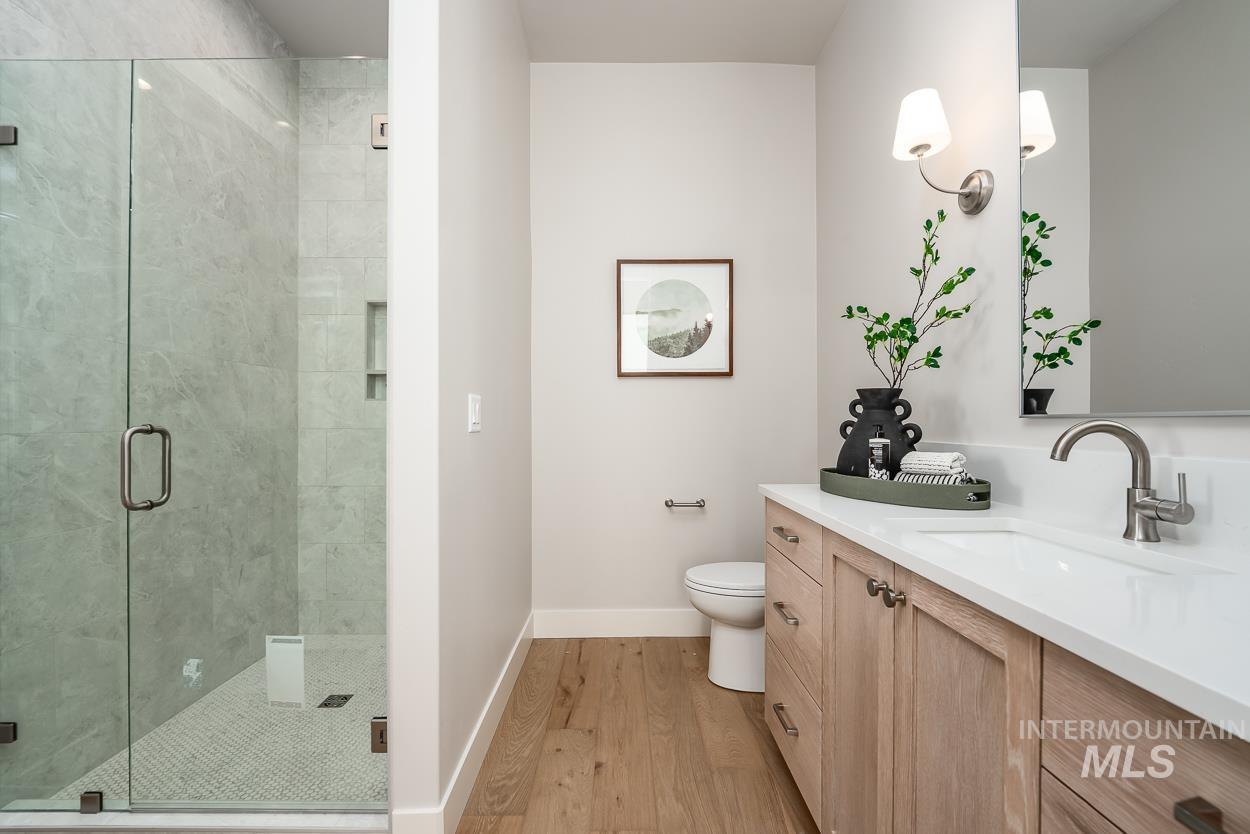 Bathroom featuring vanity, a shower stall, and light wood finished floors