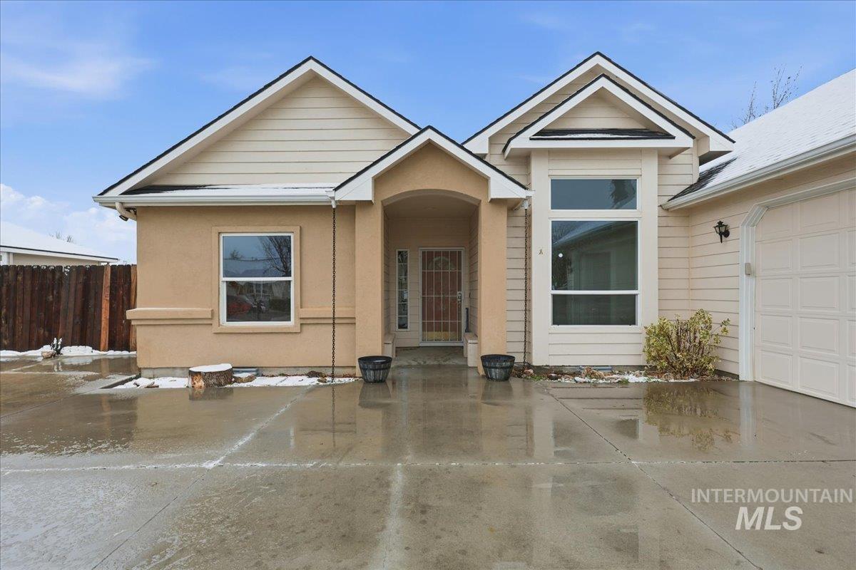 View of front of house featuring an attached garage and stucco siding
