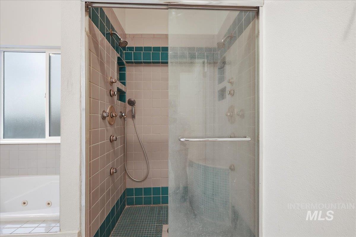 Tiled shower with multiple spray heads in master bathroom