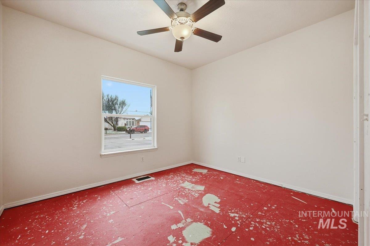 Bedroom 2 with ceiling fan. Subfloor pictured as room needs carpeting or other flooring.