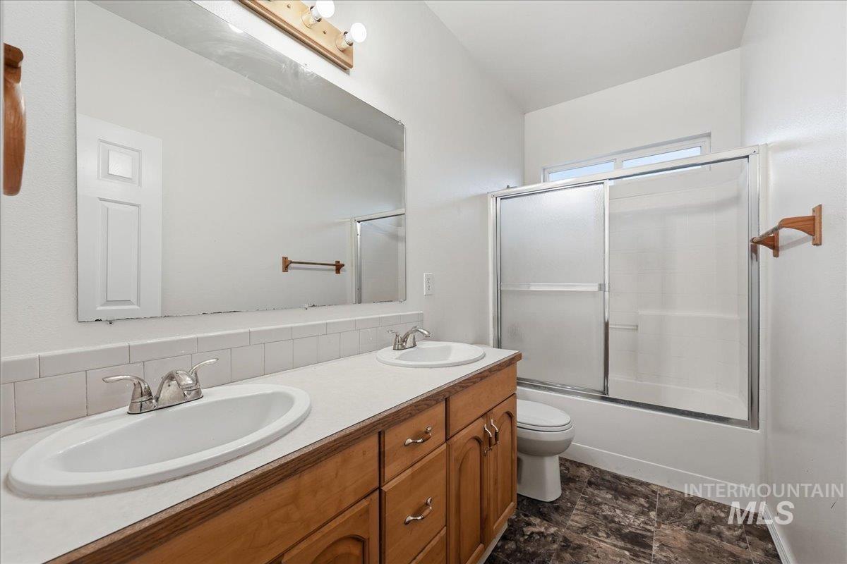 Full bathroom with single vanity, combined bath / shower with glass door