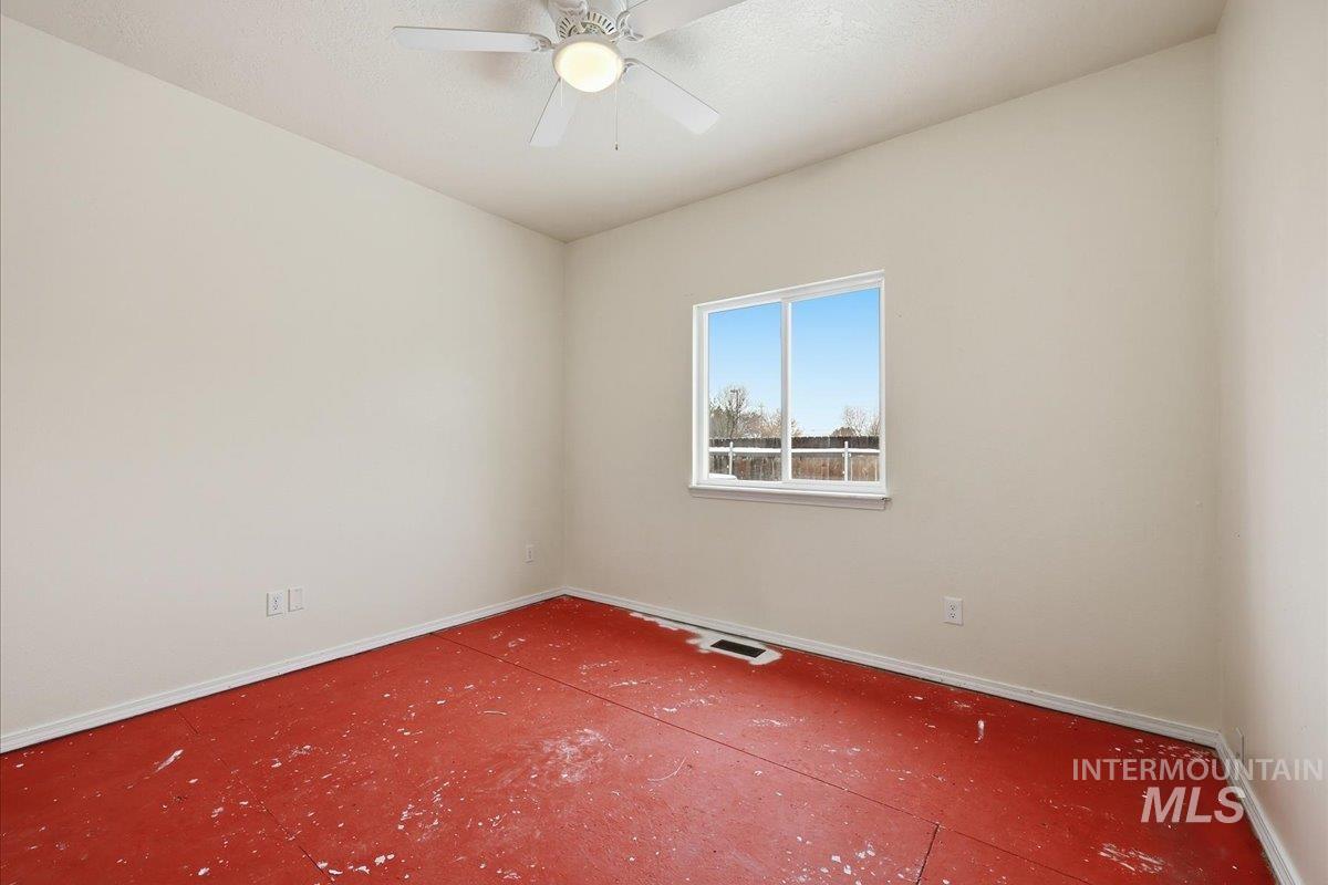 3rd bedroom with ceiling fan. Subfloor viewed in picure as room needs carpet or other flooring