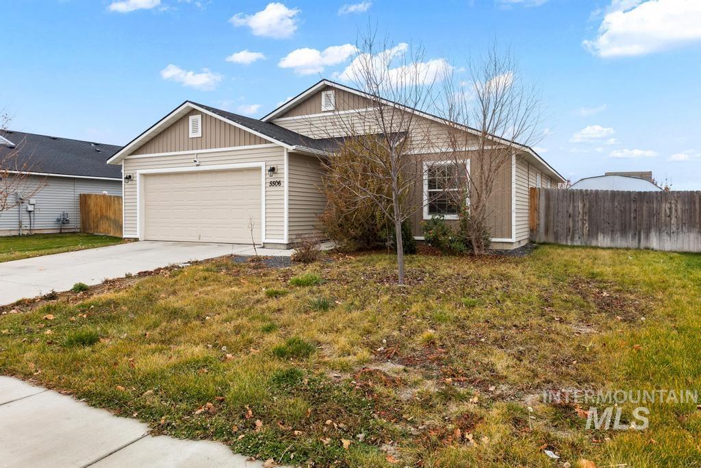 View of front of house with concrete driveway, board and batten siding, and a garage