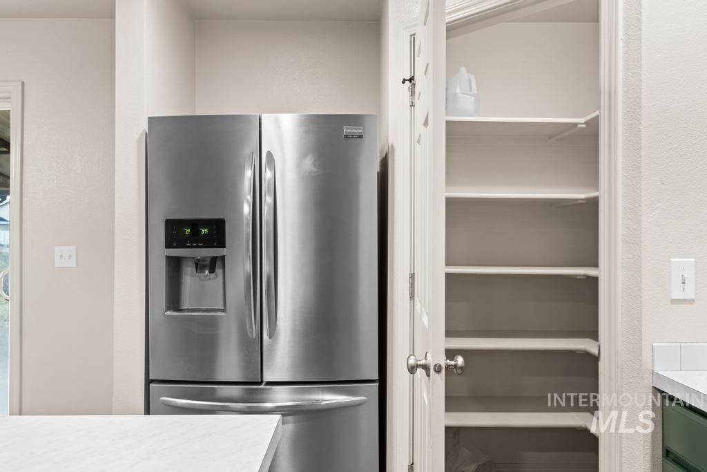 Kitchen with stainless steel fridge and light countertops
