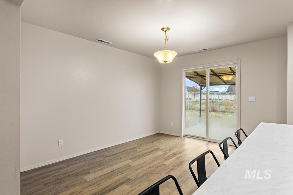 Unfurnished dining area featuring light wood finished floors and baseboards