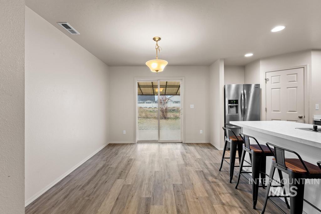 Dining room with light wood-style flooring and recessed lighting